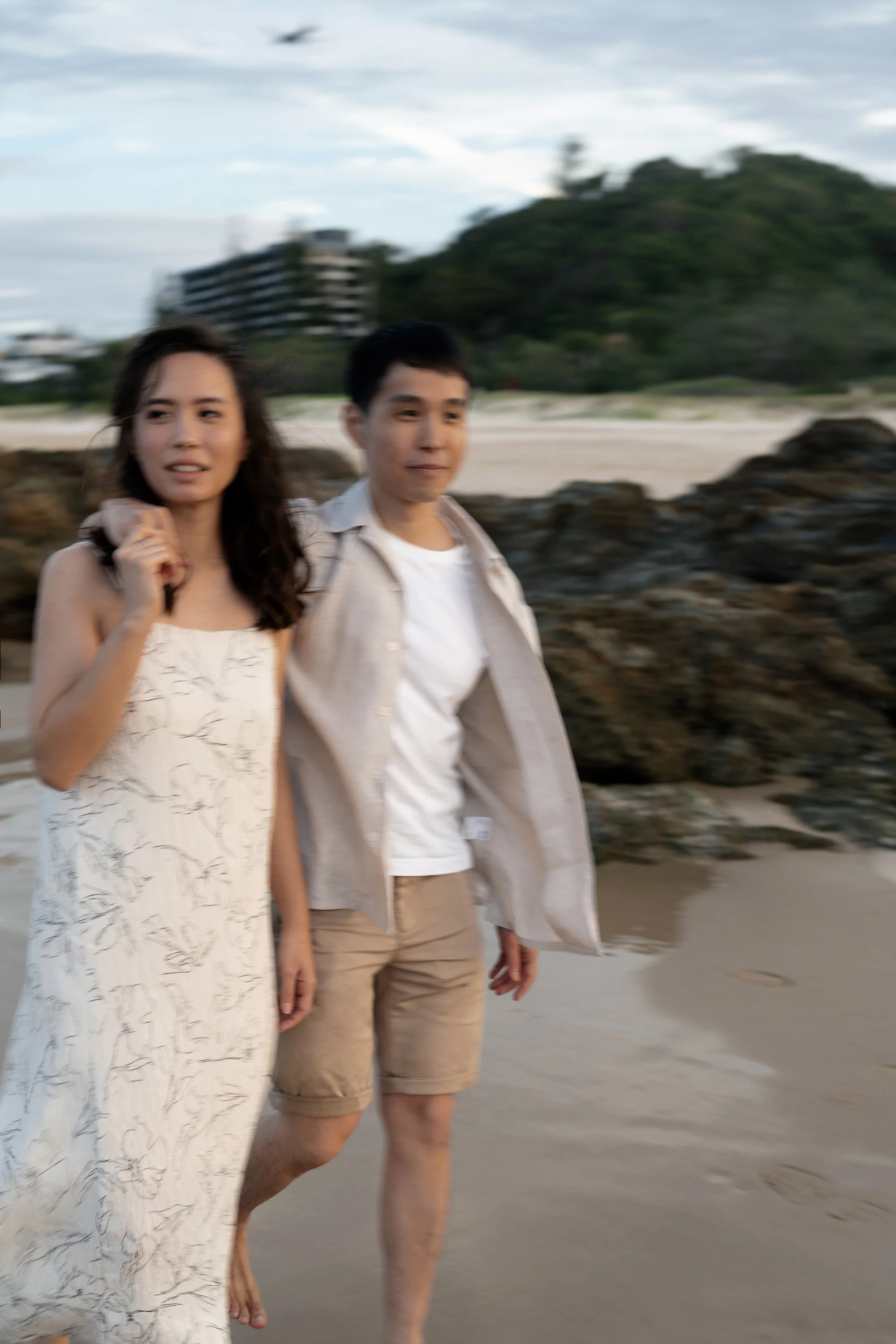 Paul holding Krystel's shoulder and she holding his hand look away in Currumbin Rock