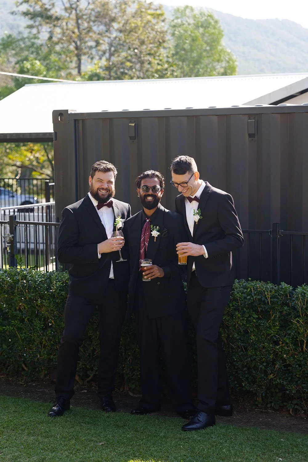 Jay in the middle and his groomsmen one on each side laughing