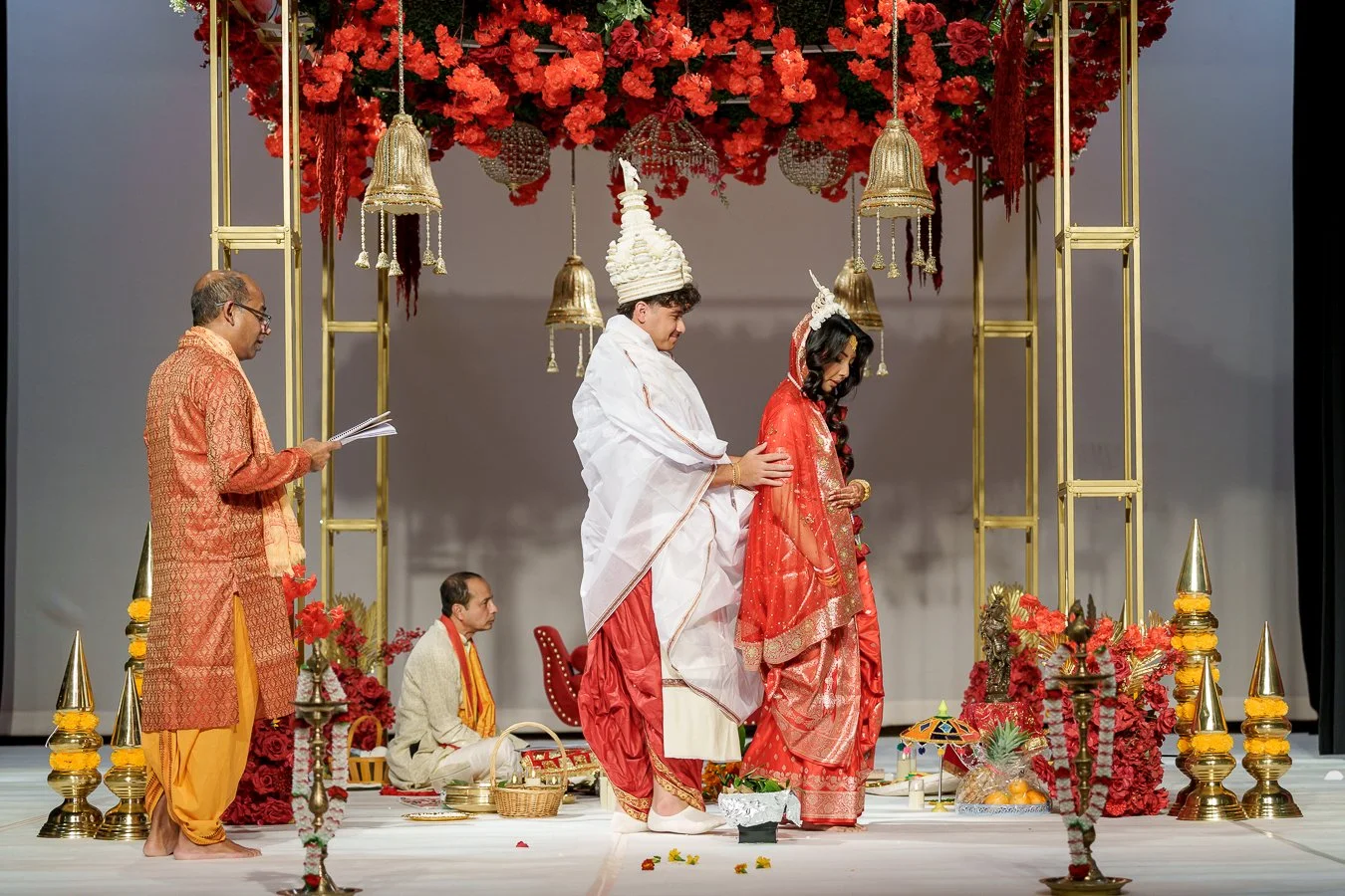 Casey holding Amrita from back and they walk together around the fire box on stage with smell
