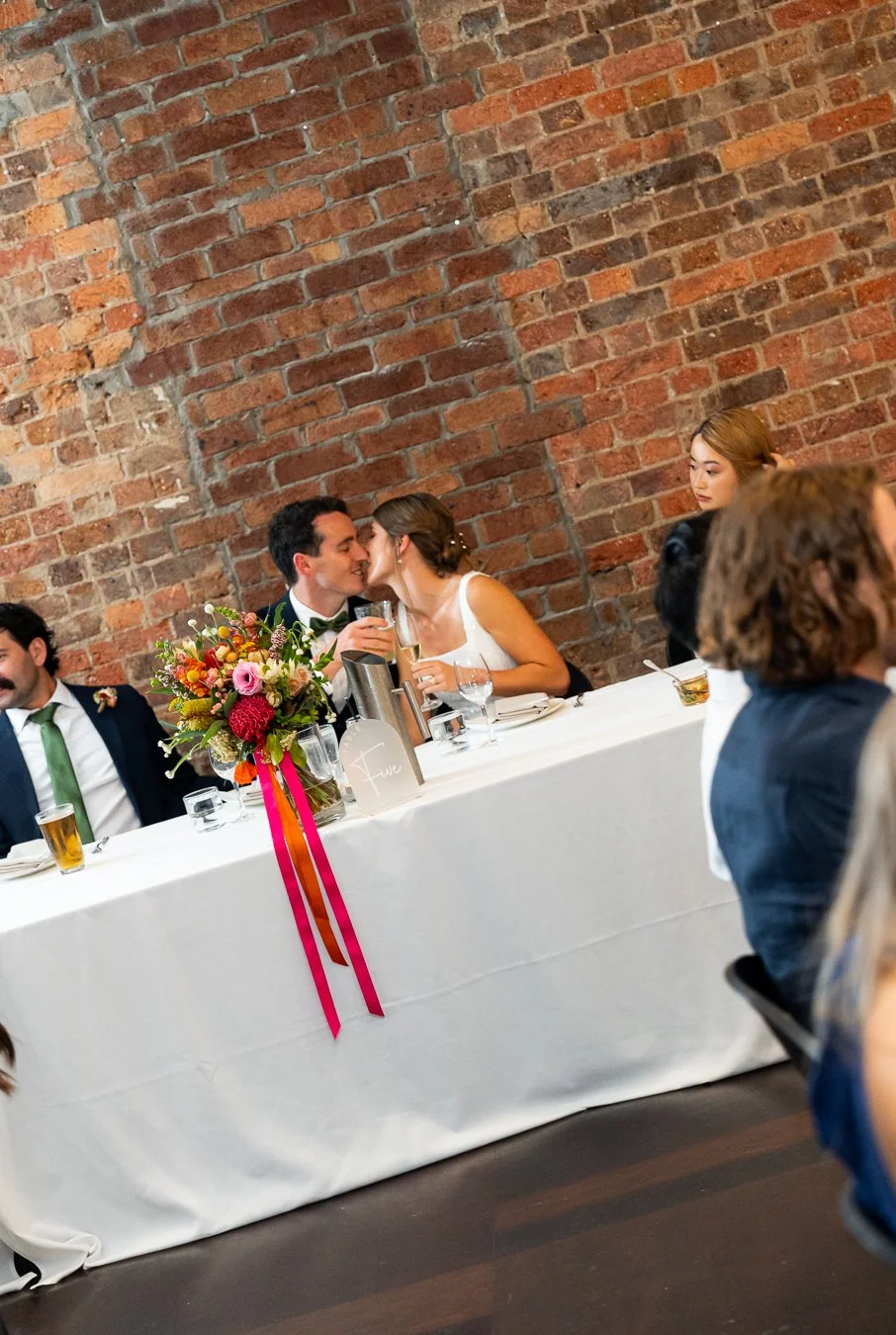 Sonya and Giordan kissing behind the table