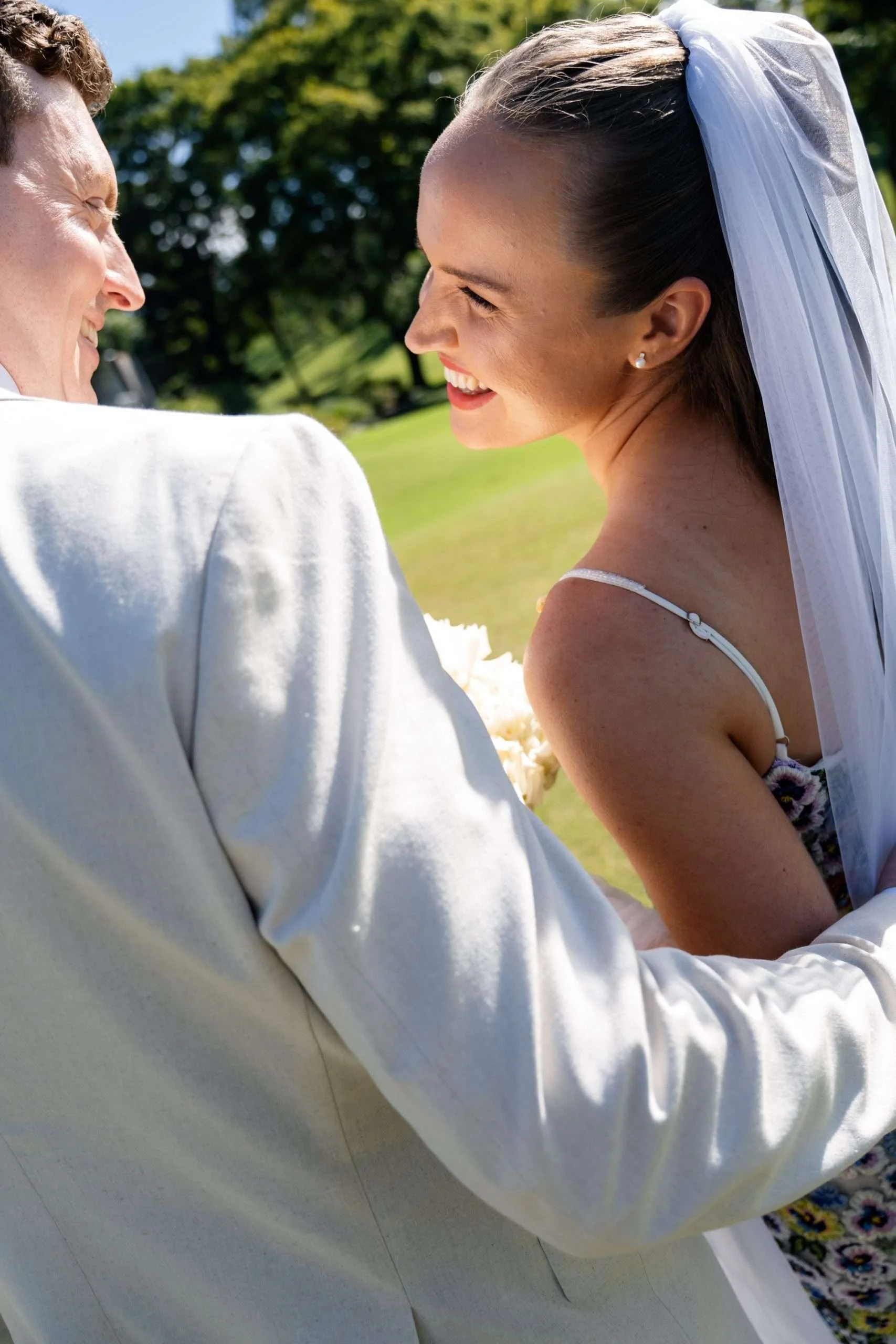 Bride looking at the groom while showing their backs to the camera.