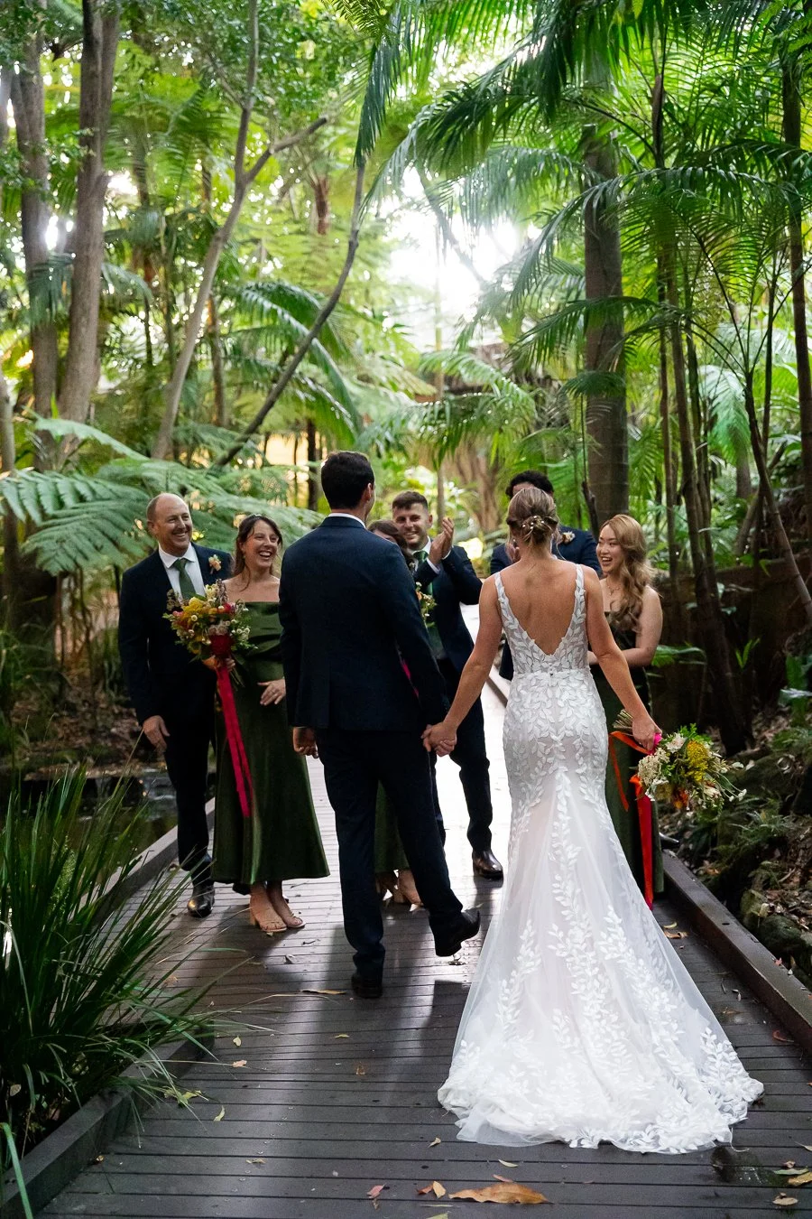 bride and groom walking towards to their bridal party