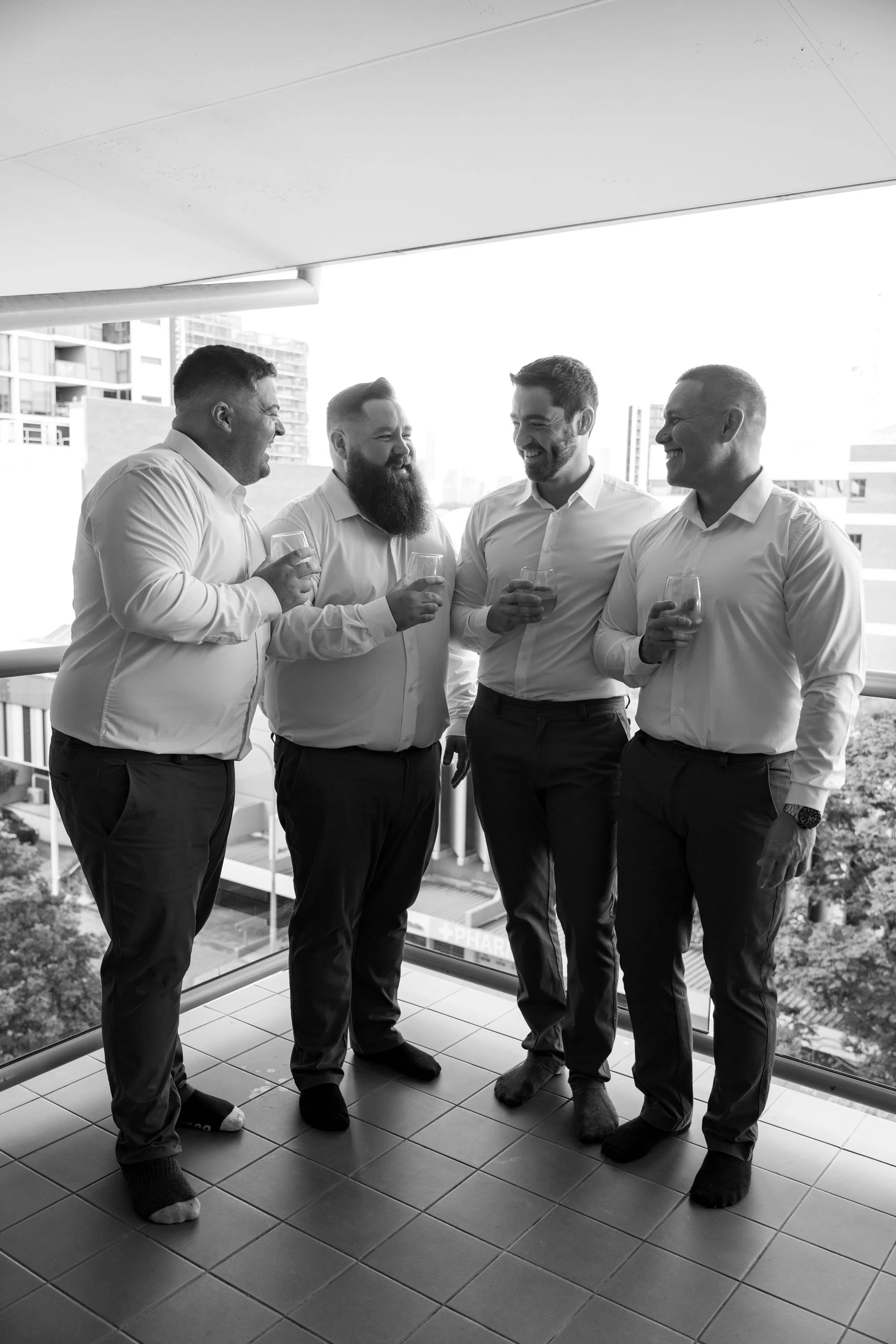 Groom Thomas talking to his groomsmen, sharing a moment of camaraderie and excitement as they prepare for the wedding ceremony