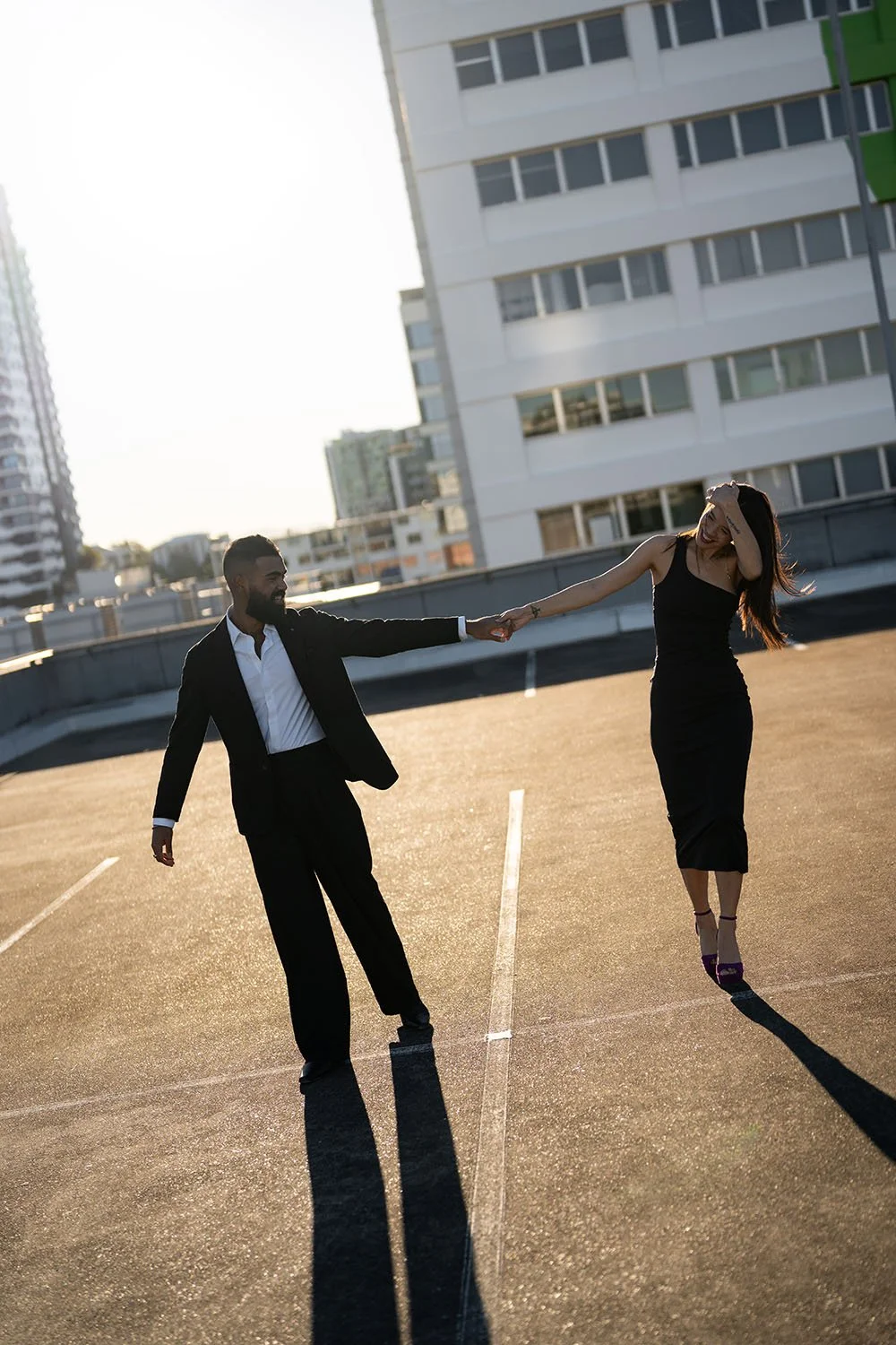 Jasmin pull back her hair when they holding hands standing on a car park roof top
