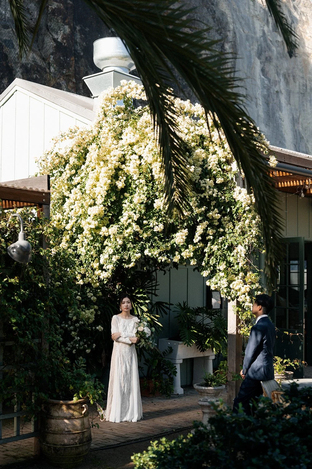 bride Cassie look at the Brisbane wedding photographer Whistler and groom sitting 4 steps away from her and look at her in Wilson Outlook Reserve
