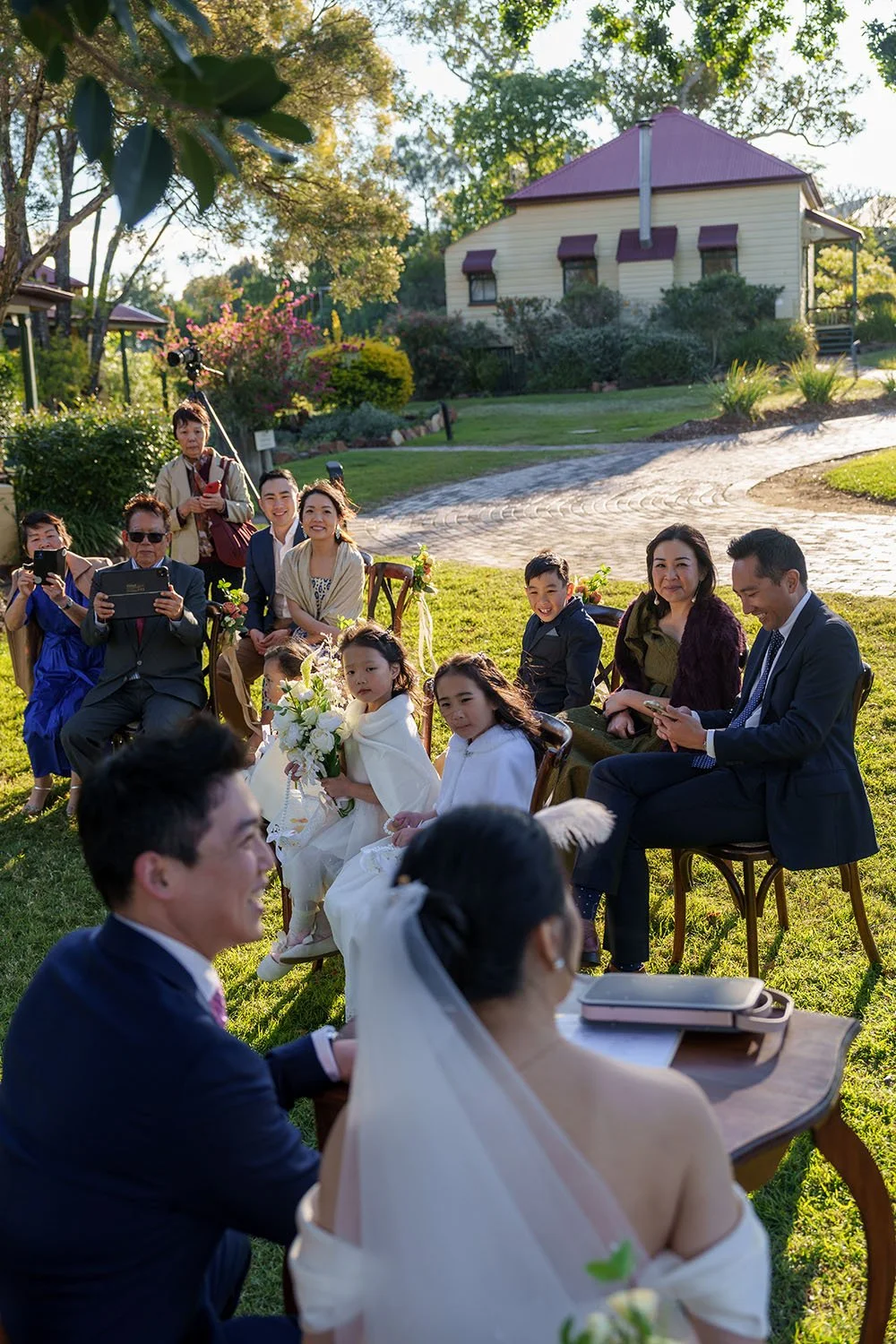 all their guests look to Eric and Flora signing the wedding registry paper
