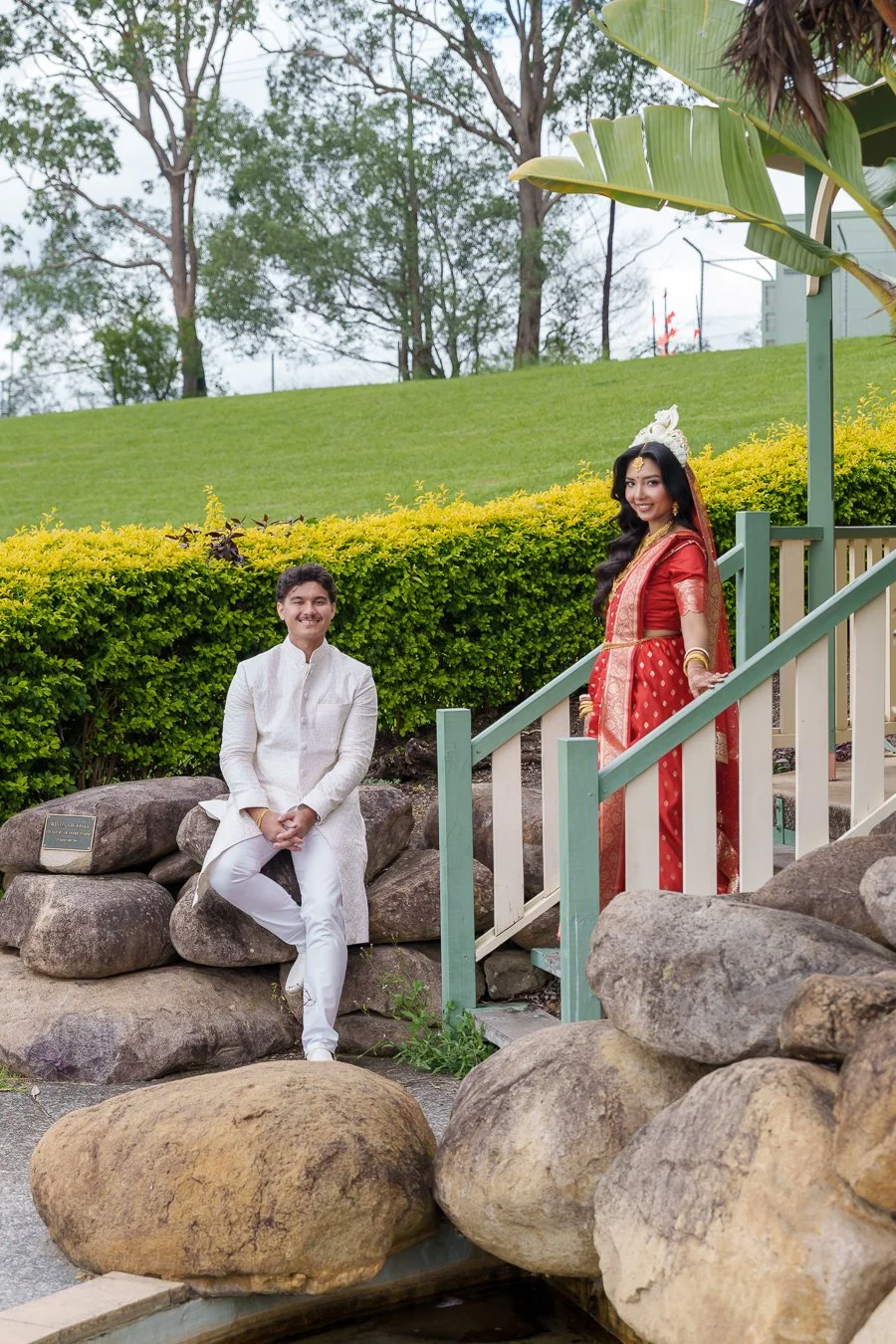 Amrita hands on the rail and Casey sitting on the rock both look at the Brisbane wedding photographer Whistler Li