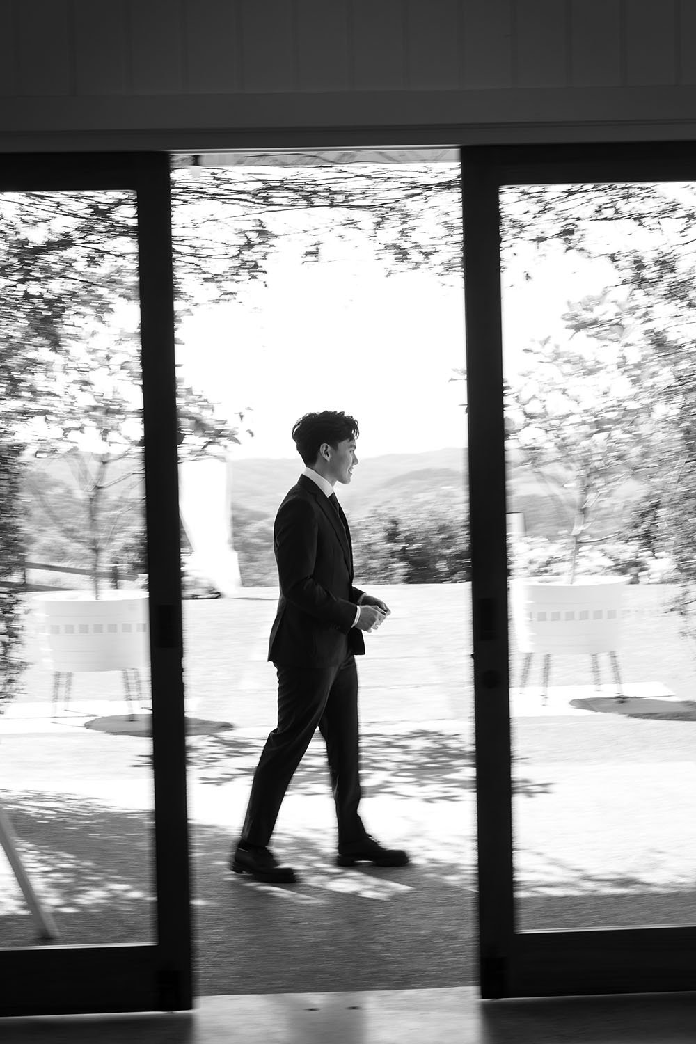 Michael walking pass a glass door