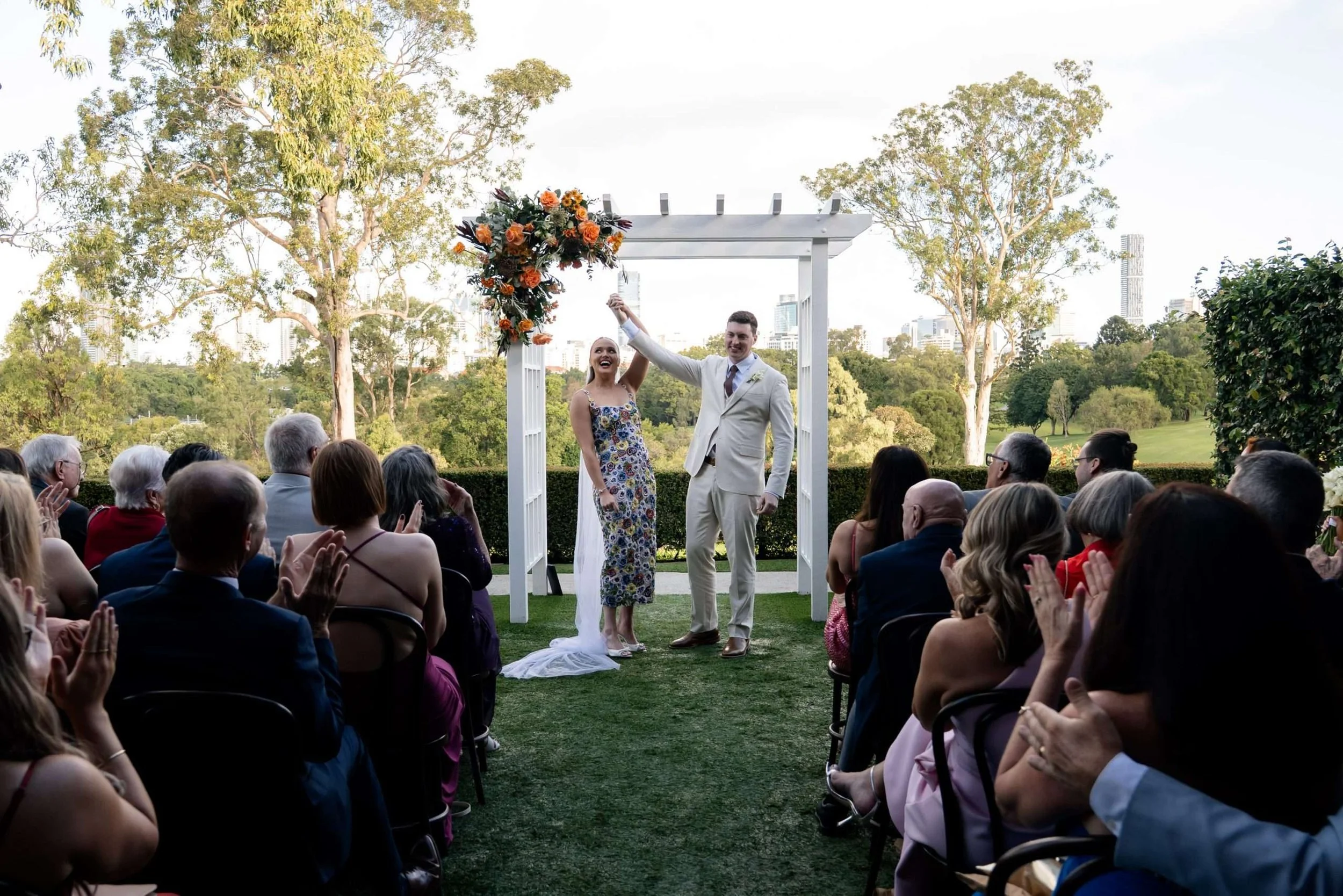 bride and groom holding hands up and look to all the guests while they cheers for them mirage.
