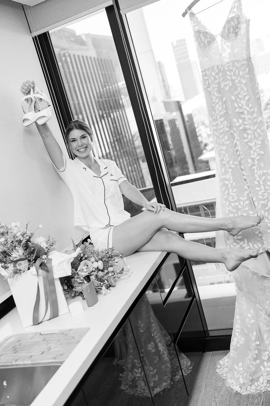 The bride held up her shoes, happily looking at the Brisbane wedding photographer Whistler Li