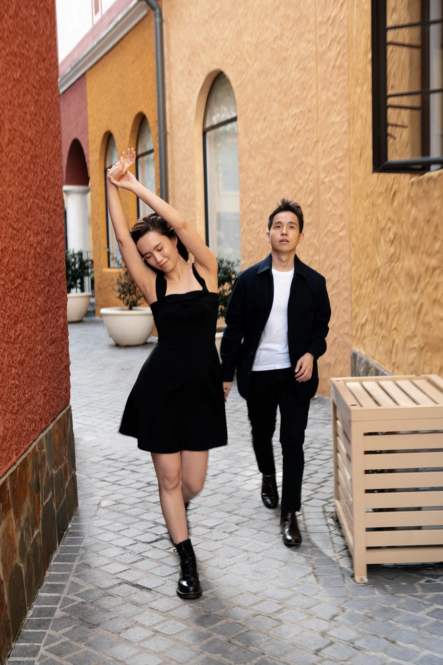 Krystel stretching lazily and Paul walking together with her in Emerald Lakes Village