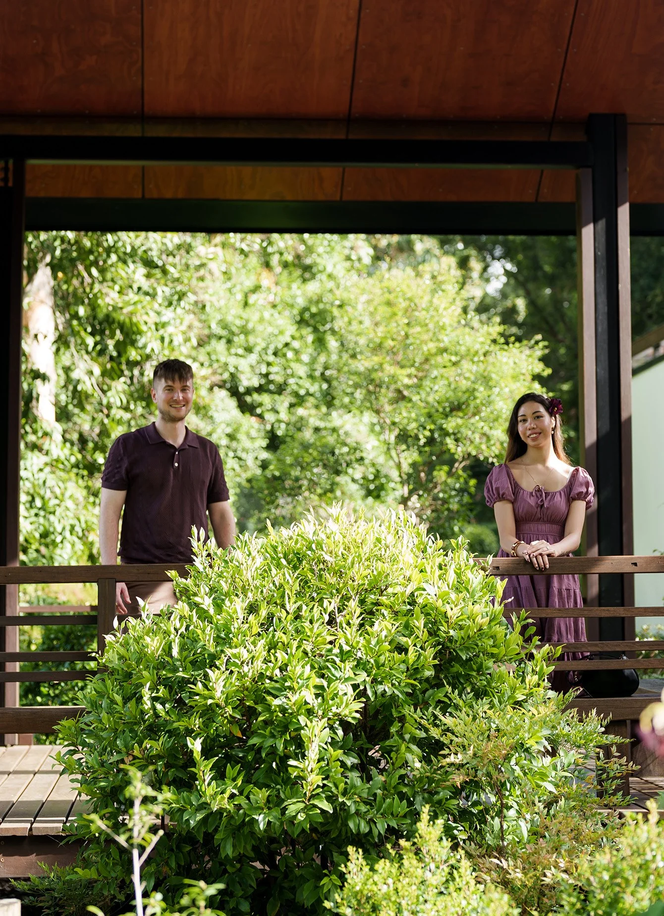 Ruby touch the rail and Kyle stand next to rail under a gazebo in Brisbane Botanic Gardens Mt Coot-tha