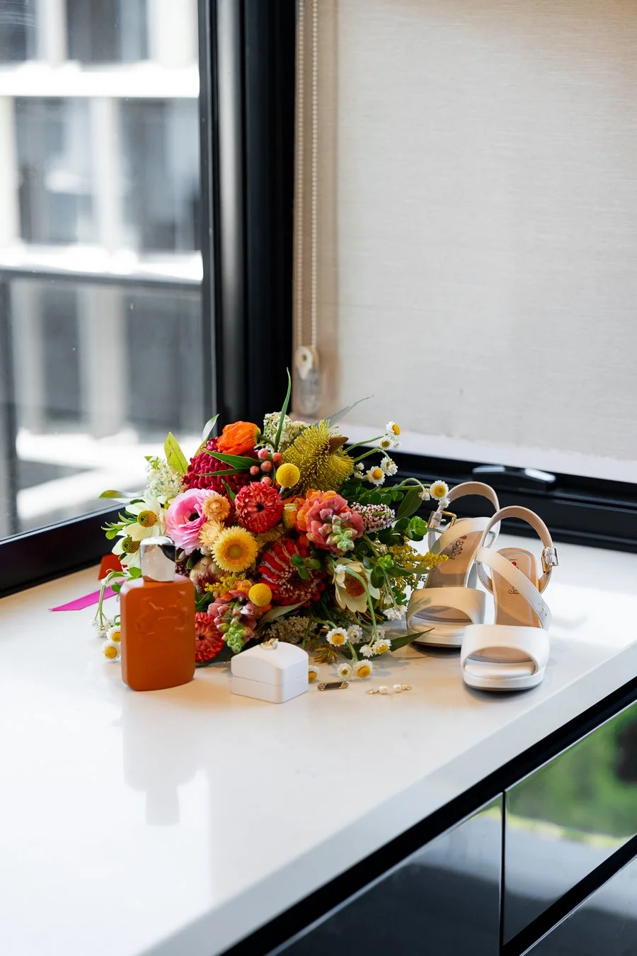 The bride’s shoes, flowers, jewelry, perfume, and engagement ring were placed on the table