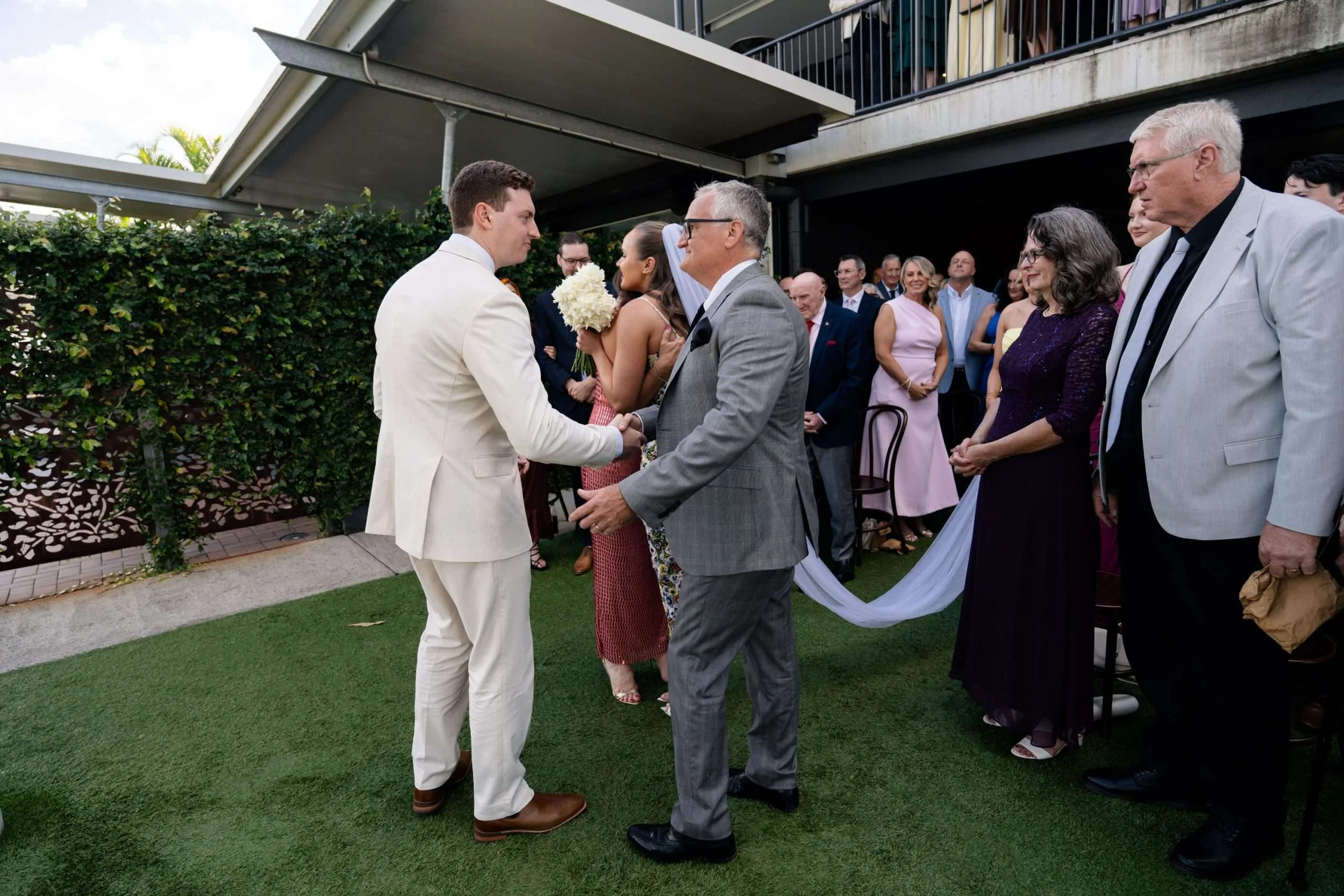 groom Jack shaking hands to bride's father, and bride hugging her mother