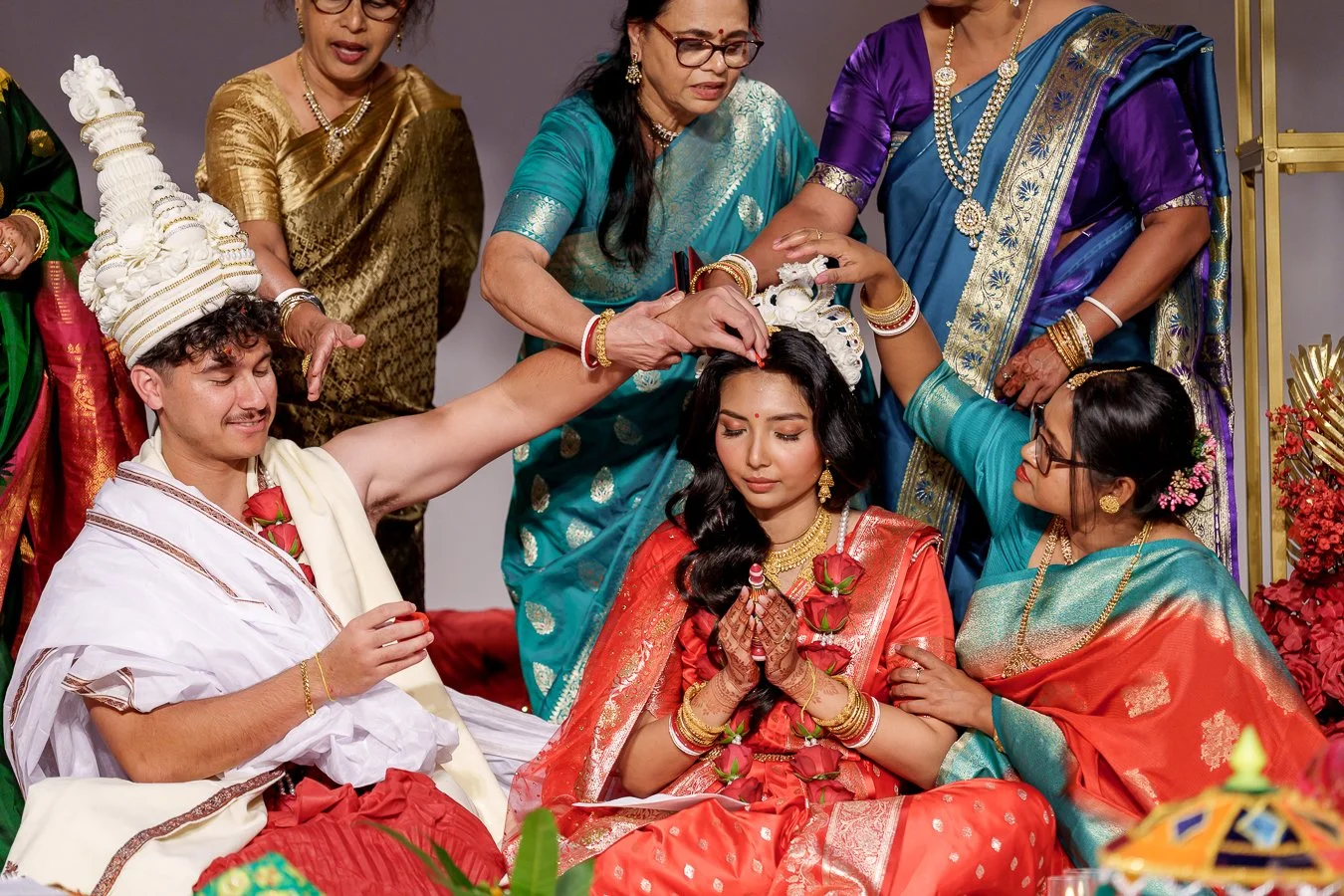 Casey holding the wedding ring with red colour on it, calms Amrita's hair
