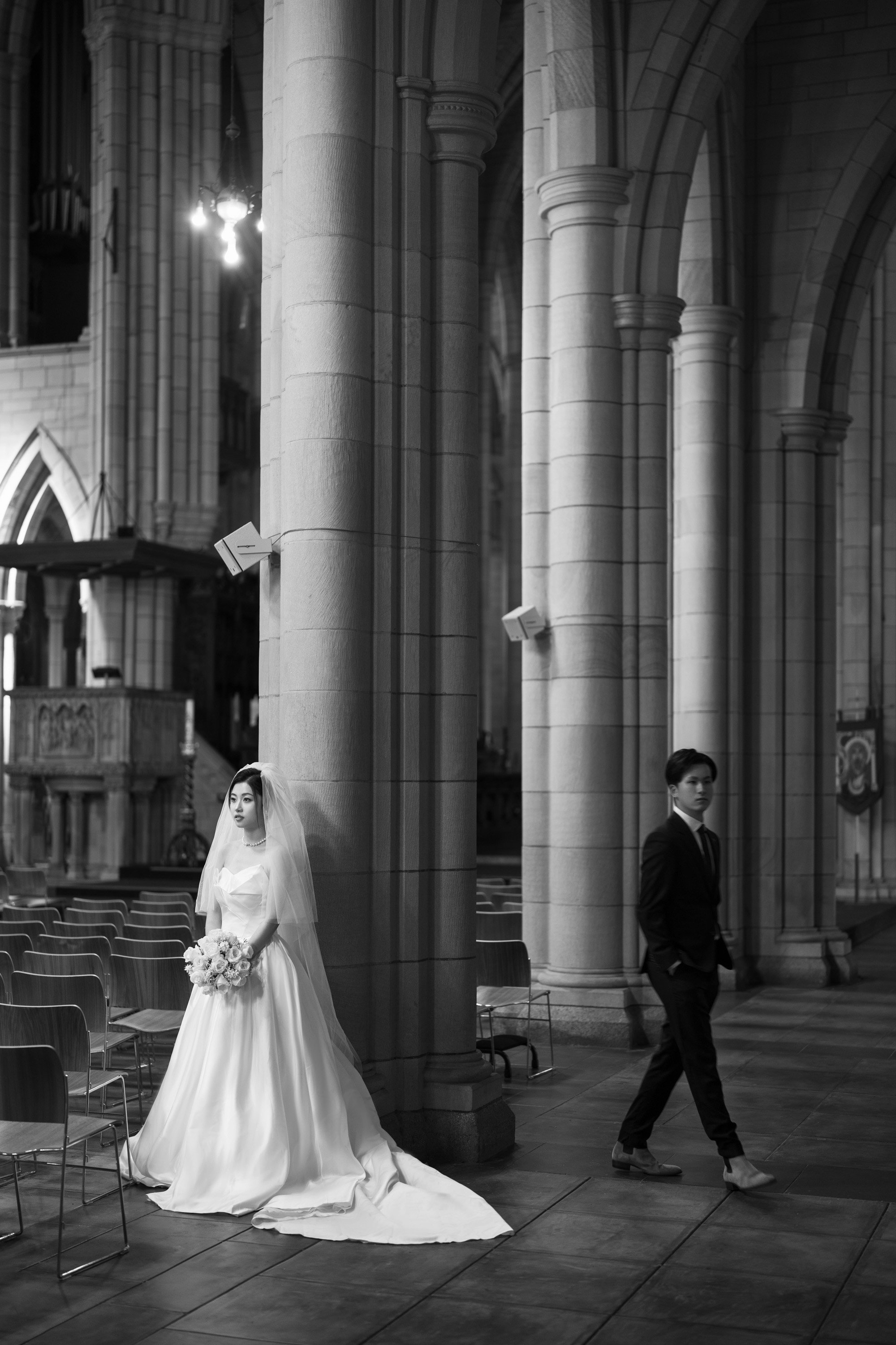 bride standing their and groom walking next to her