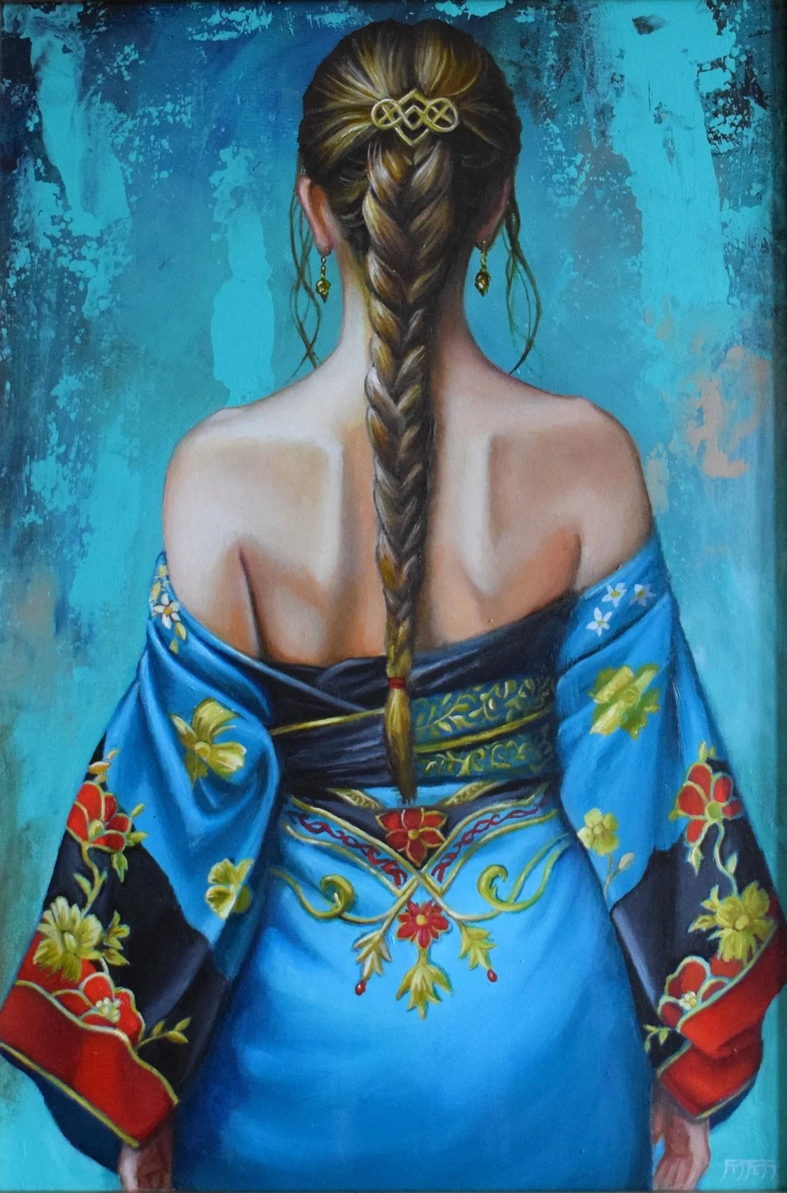 A woman with braided hair wearing a blue dress with floral embroidery. She is seen from the back with a turquoise background.