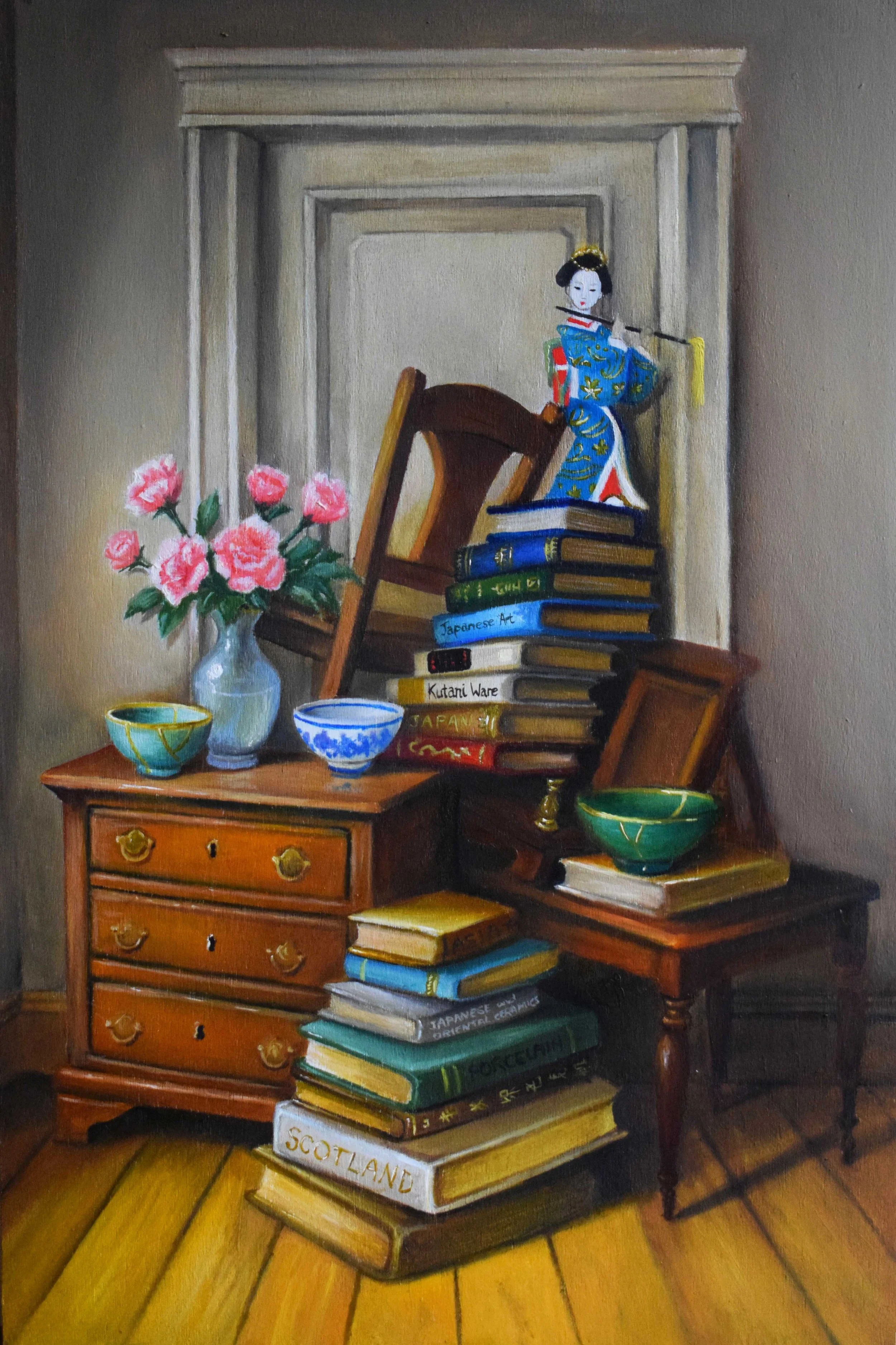 A still life painting of a wooden table with a small chest of drawers, a stack of books, a potted pink flower, and decorative bowls. There is a figurine of a geisha on top of the books, with a background of a mantle and wooden flooring.