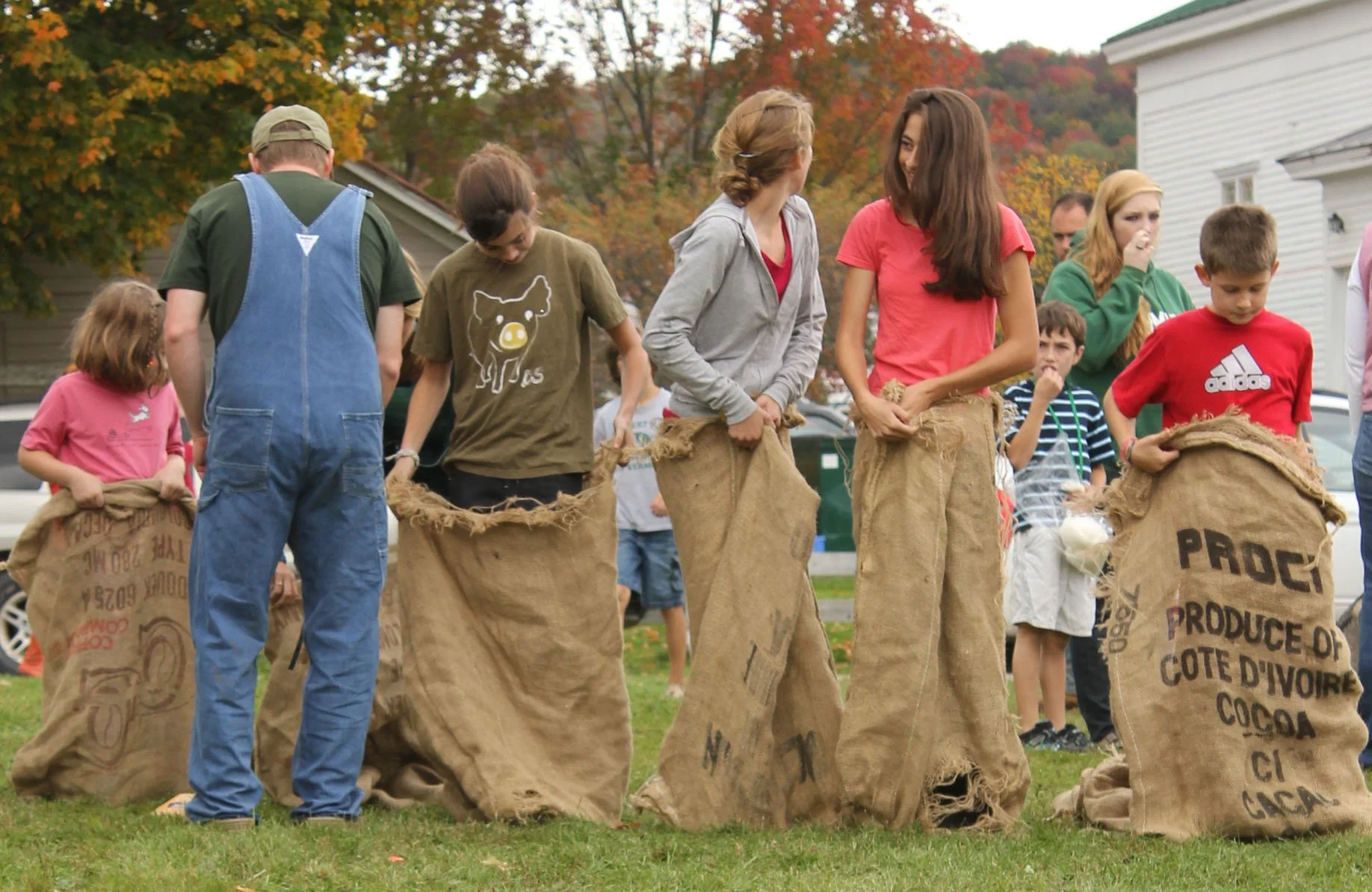 Teens preparing for a race within burlap sacks on a fall day