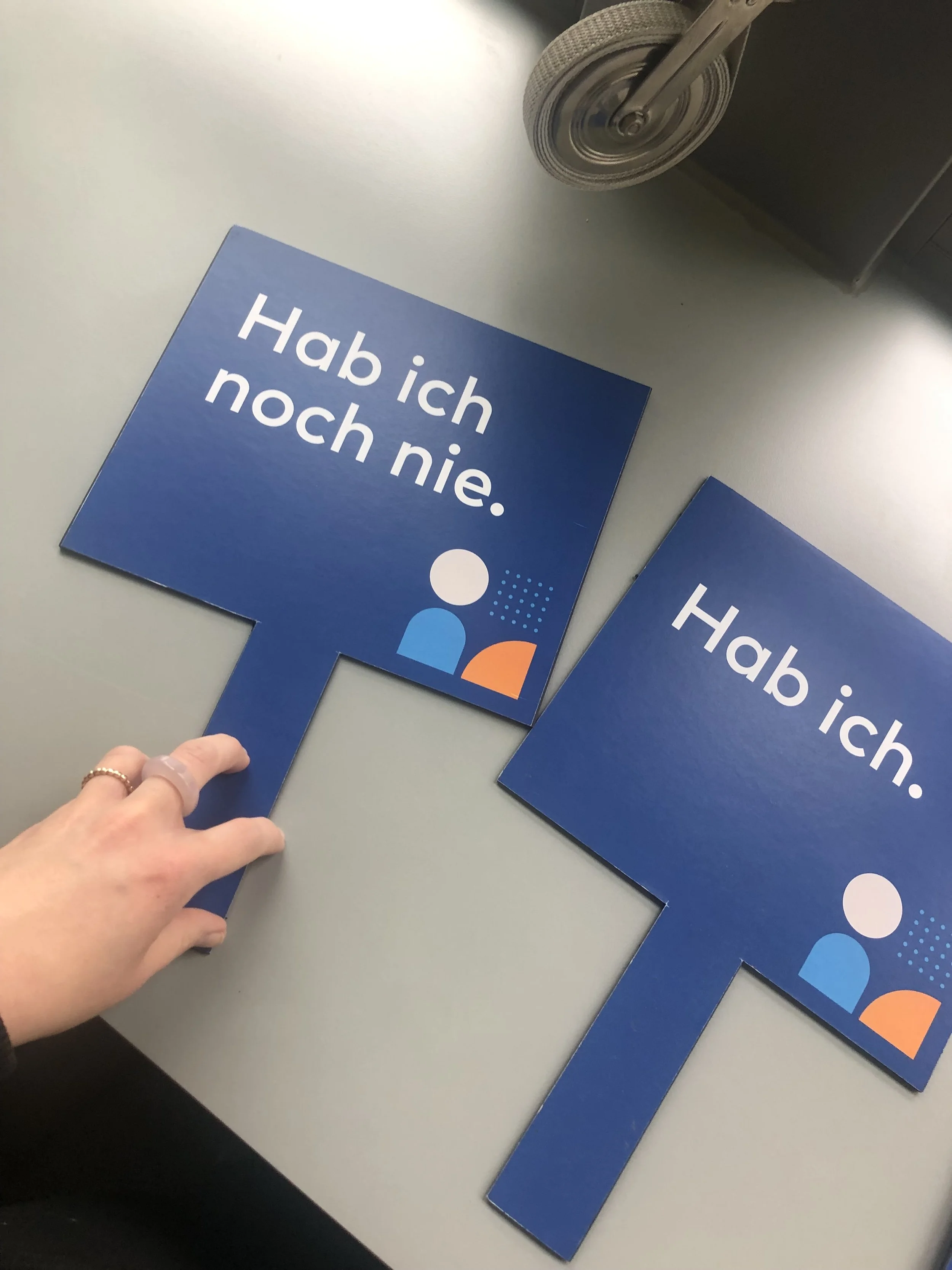Blaue Schilder mit weißem Text, die sagen: 'Hab ich noch nie.'