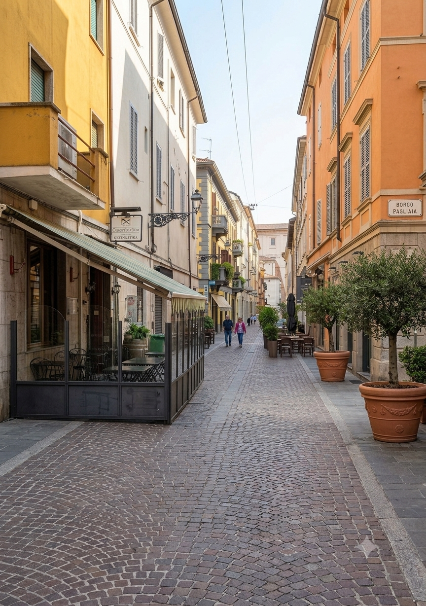 Una strada pedonale in una città europea con edifici colorati, vasi di piante e alcuni tavoli di un bar all'aperto
