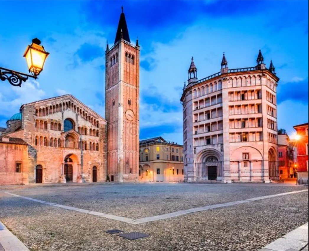 Vista della Piazza delle Erbe a Verona, con la Torre dei Lamberti e edifici storici al tramonto.