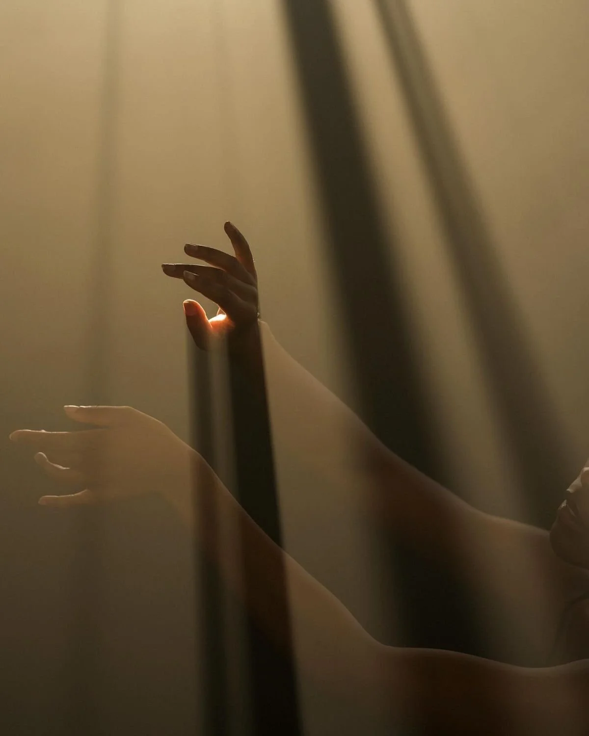 Deux mains nues visibles, une touche une surface translucide, avec un éclairage doux et chaud, créant une ambiance artistique et mystérieuse.