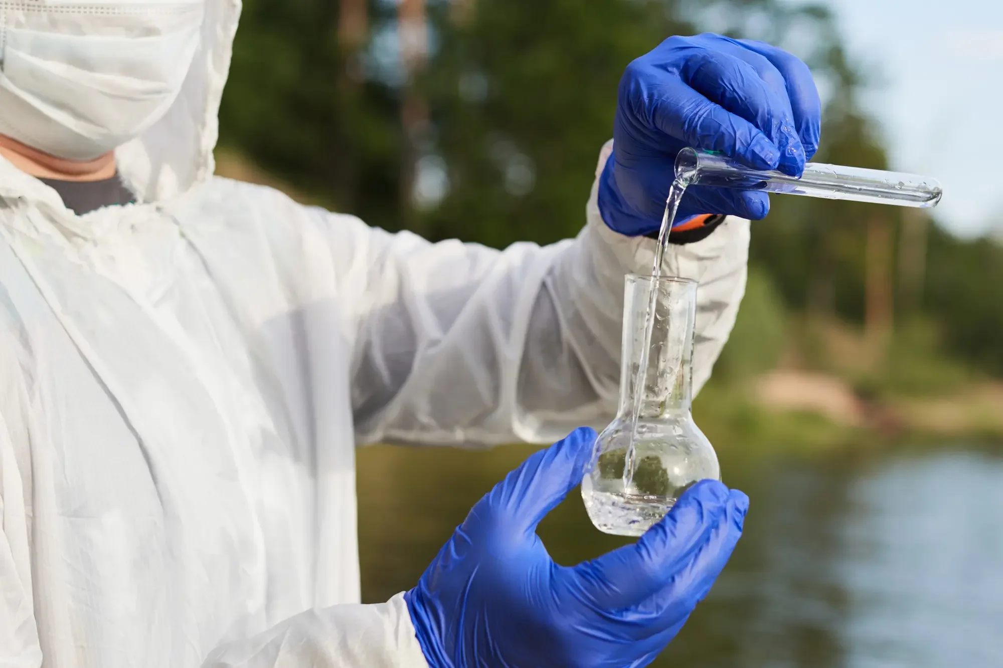 Person with gloves, testing water in a beacon.
