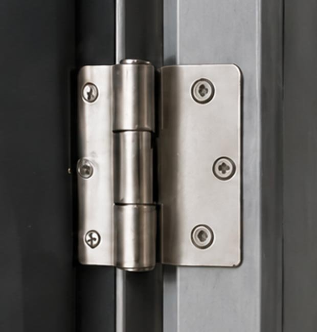 Close-up of a stainless steel door hinge and strike plate on a metal door.