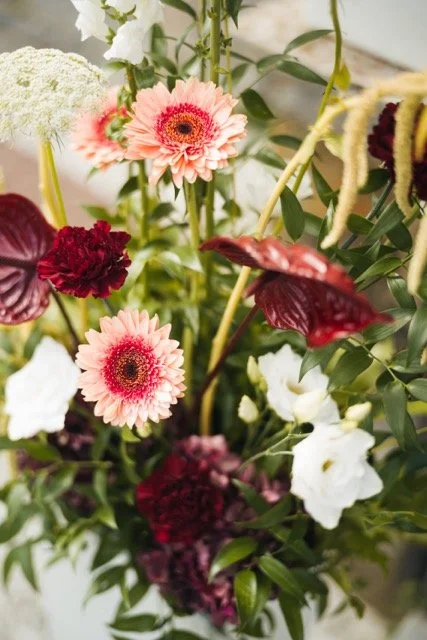 Blommor i olika färger och former i en bukett.