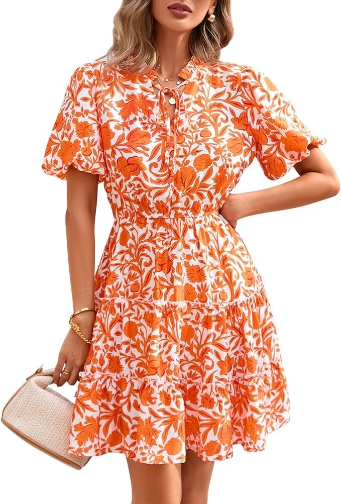 Woman wearing a short-sleeved, orange and white floral dress, holding a woven clutch bag, wearing earrings and a bracelet.