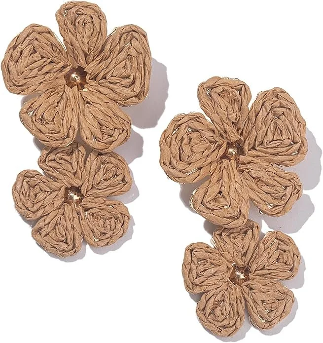 Four decorative flowers made from crumpled brown paper with gold centers, arranged on a white surface.