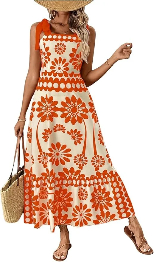 Woman wearing a sleeveless, orange and cream floral maxi dress, accessorized with a wide-brim straw hat, hoop earrings, bracelets, and sandals, carrying a woven straw tote bag against a white background.