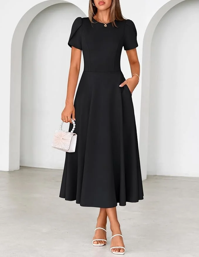 Woman wearing a black, floor-length dress with puffed sleeves, holding a small white handbag with a pearl handle, standing in front of white arches.