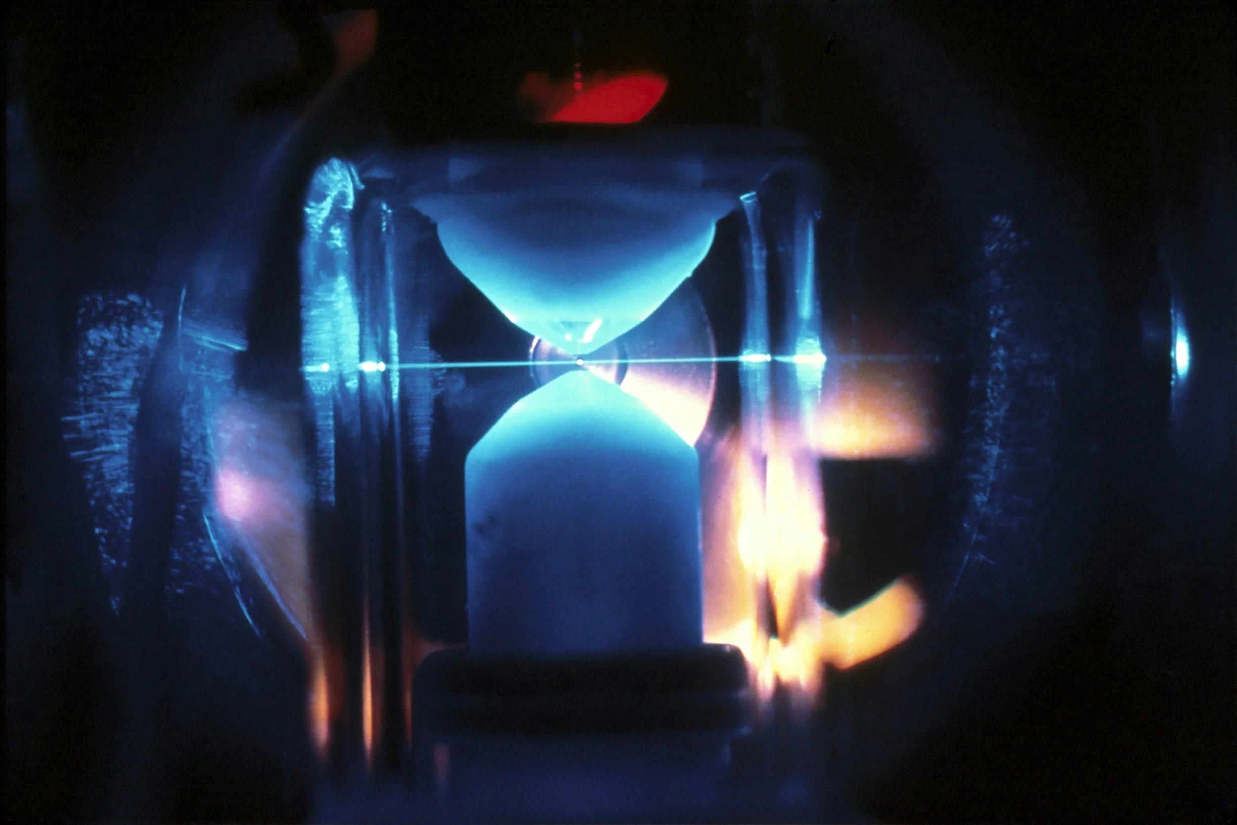 Blue and orange light interacting with a material sample, representing time-resolved spectroscopy.