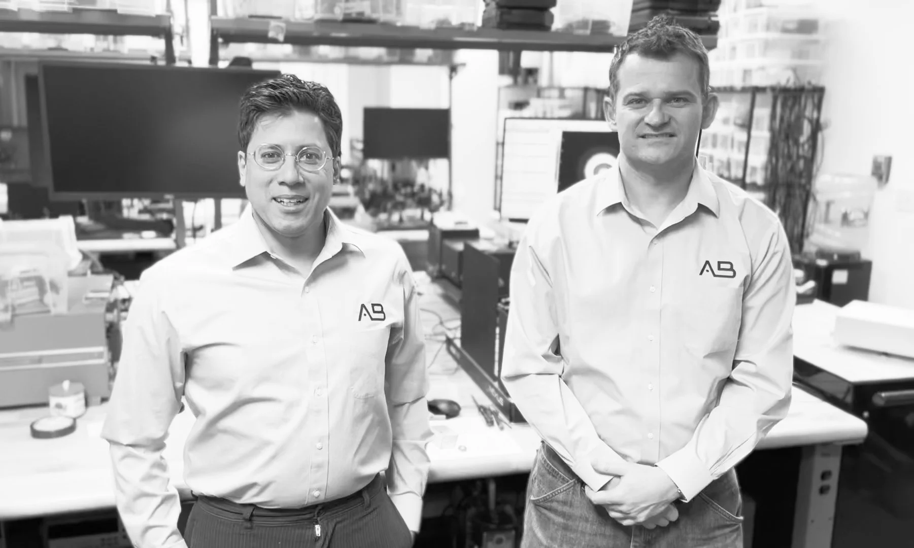 AB Photonics engineers in a laboratory with optical workstations and equipment.