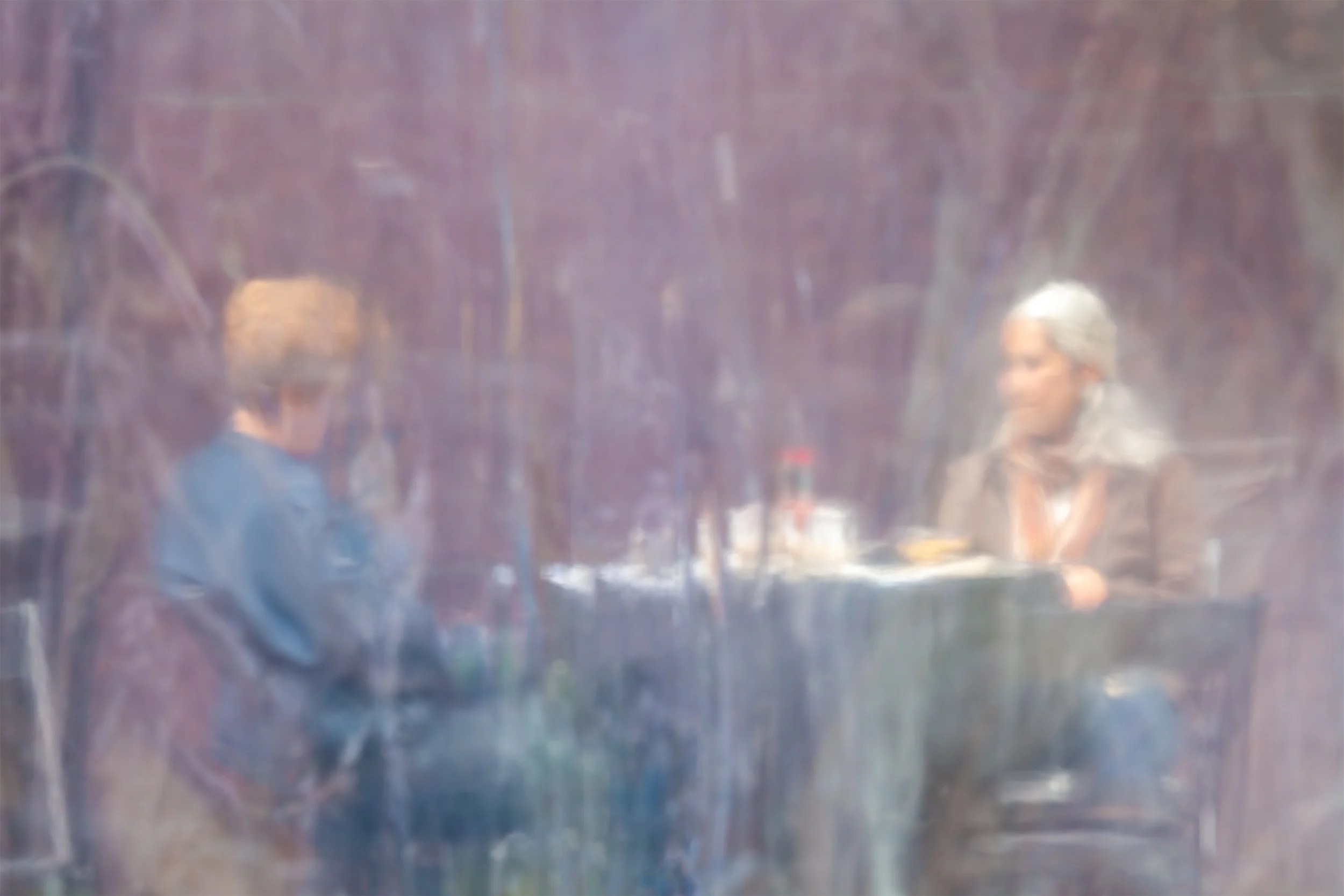 Two figures at a small table among russet autumn foliage, in soft impressionistic focus — Ken Holden's avant-garde photographic impressionism, from his Unaltered State of Reality collection.