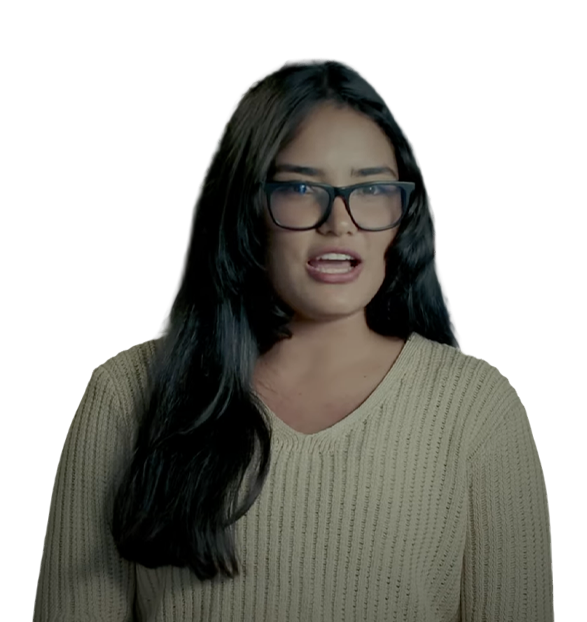 Woman with long dark hair, wearing glasses and a beige sweater, speaking or explaining something.