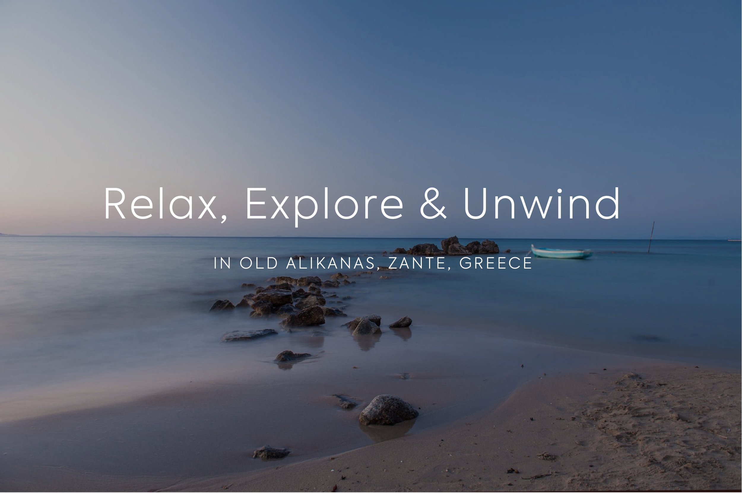 Calm sea with rocks and a small boat, clear blue sky, sunset or sunrise at Old Alikanas, Zante, Greece.