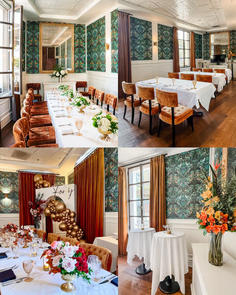 Decorated event space with floral arrangements, balloons, and elegant table settings, featuring green patterned wallpaper, large windows with curtains, and varied table decor for celebration or gathering.