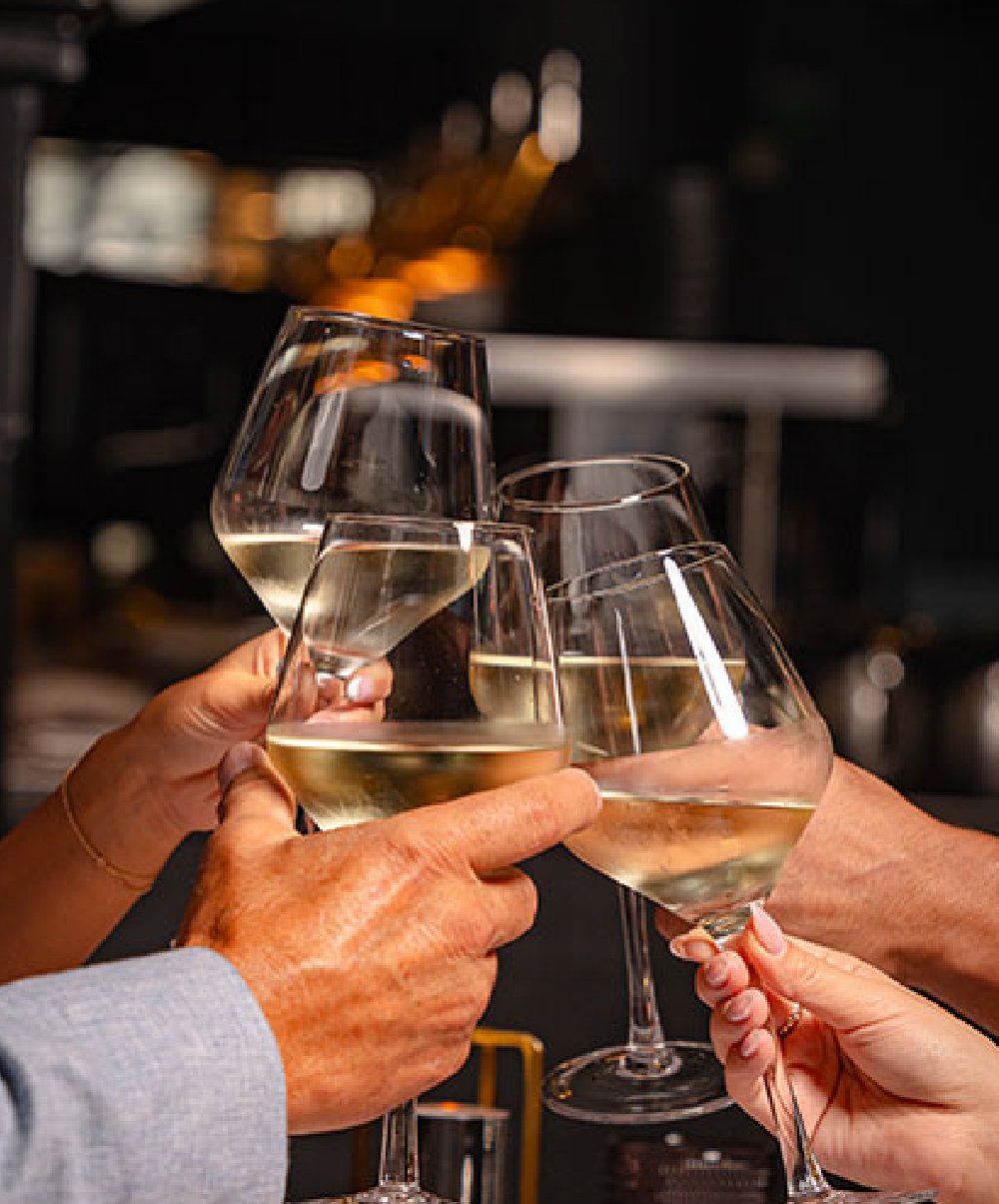 Clinking glasses of white wine in a toast