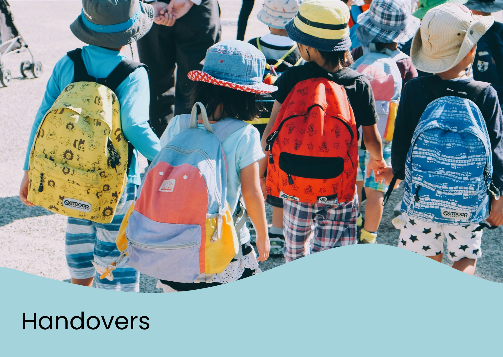 Children wearing colorful backpacks and hats, holding hands, outdoors, during daytime.