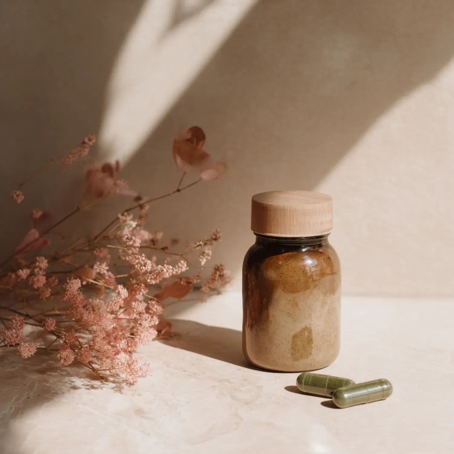 A glass containing dietary supplement capsules and dried flowers—a symbolic image representing nutrition and gut health
