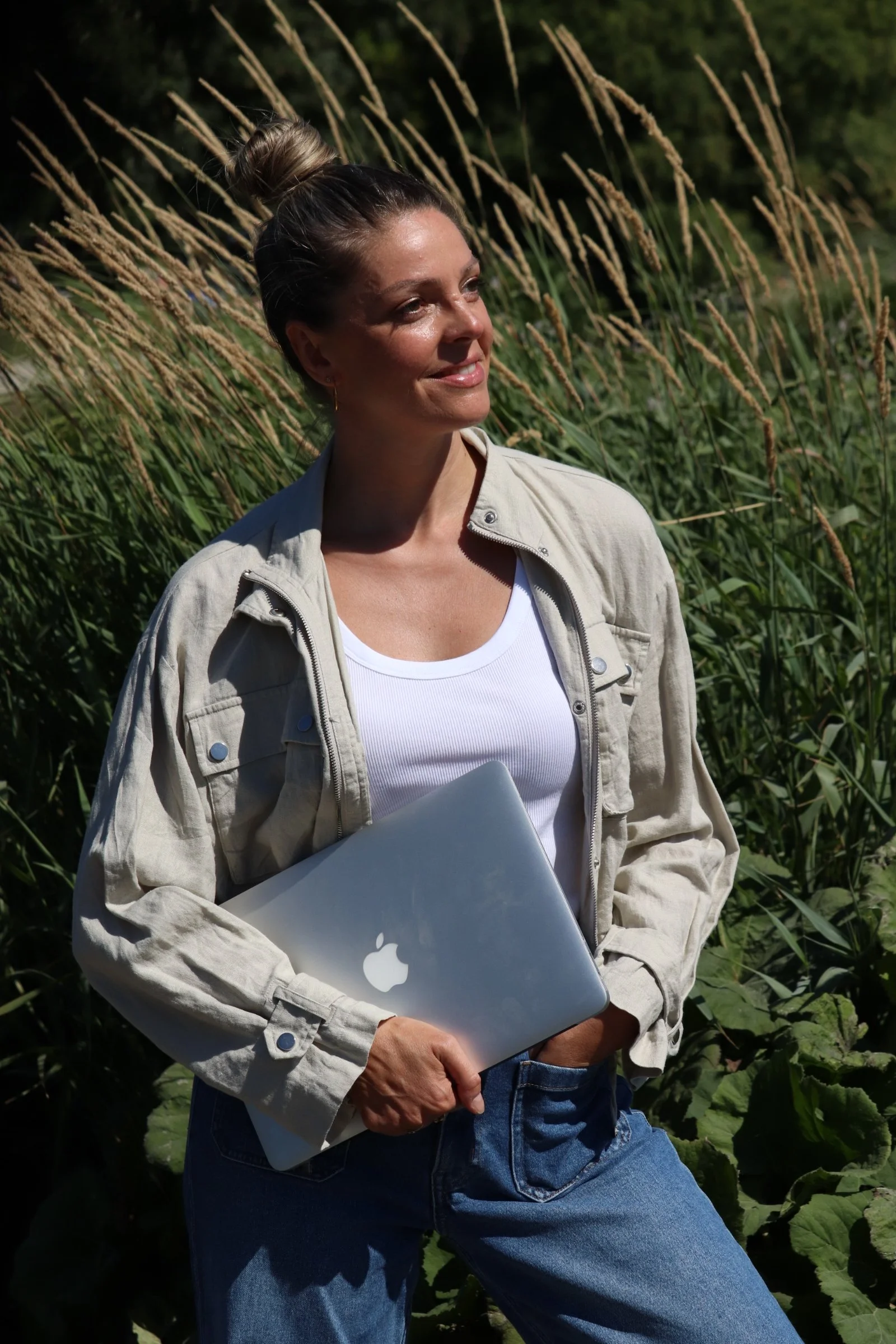 Petra Psenner with her laptop in front of dark wood paneling—a health coach in Munich at work