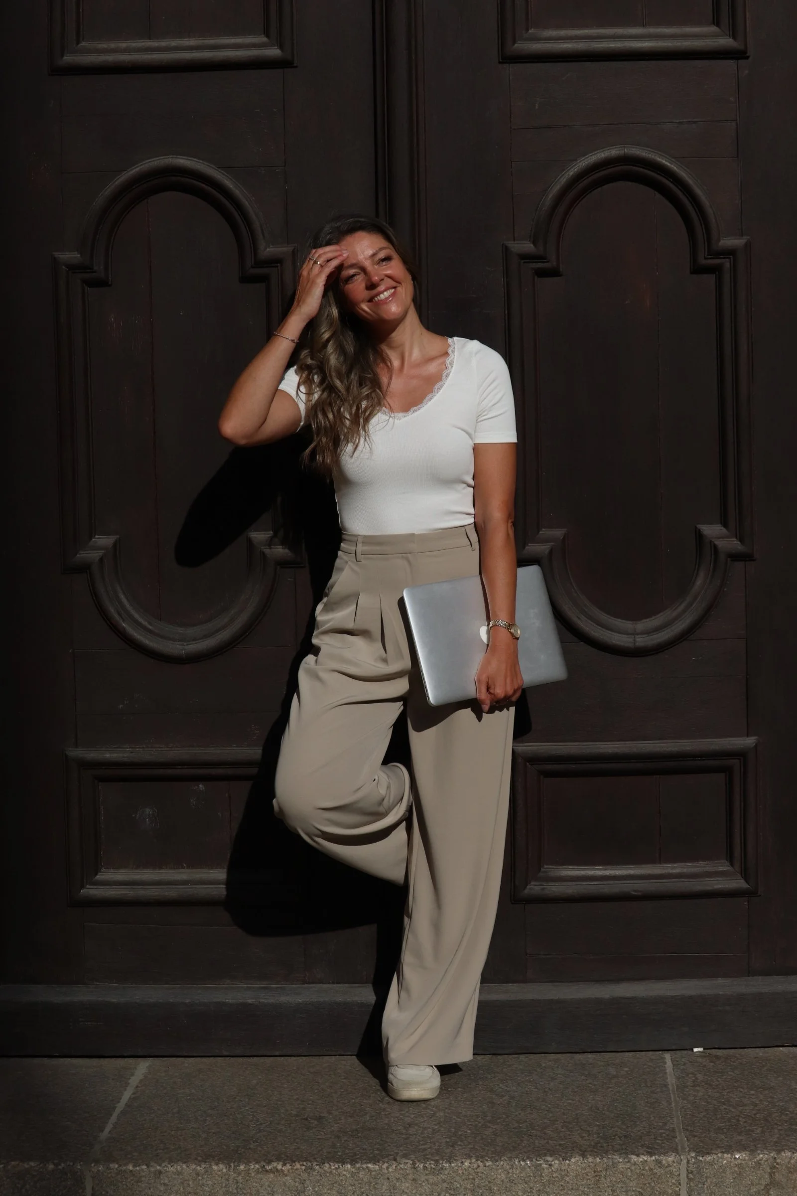 Petra Psenner with her laptop in front of dark wood paneling—a health coach at work