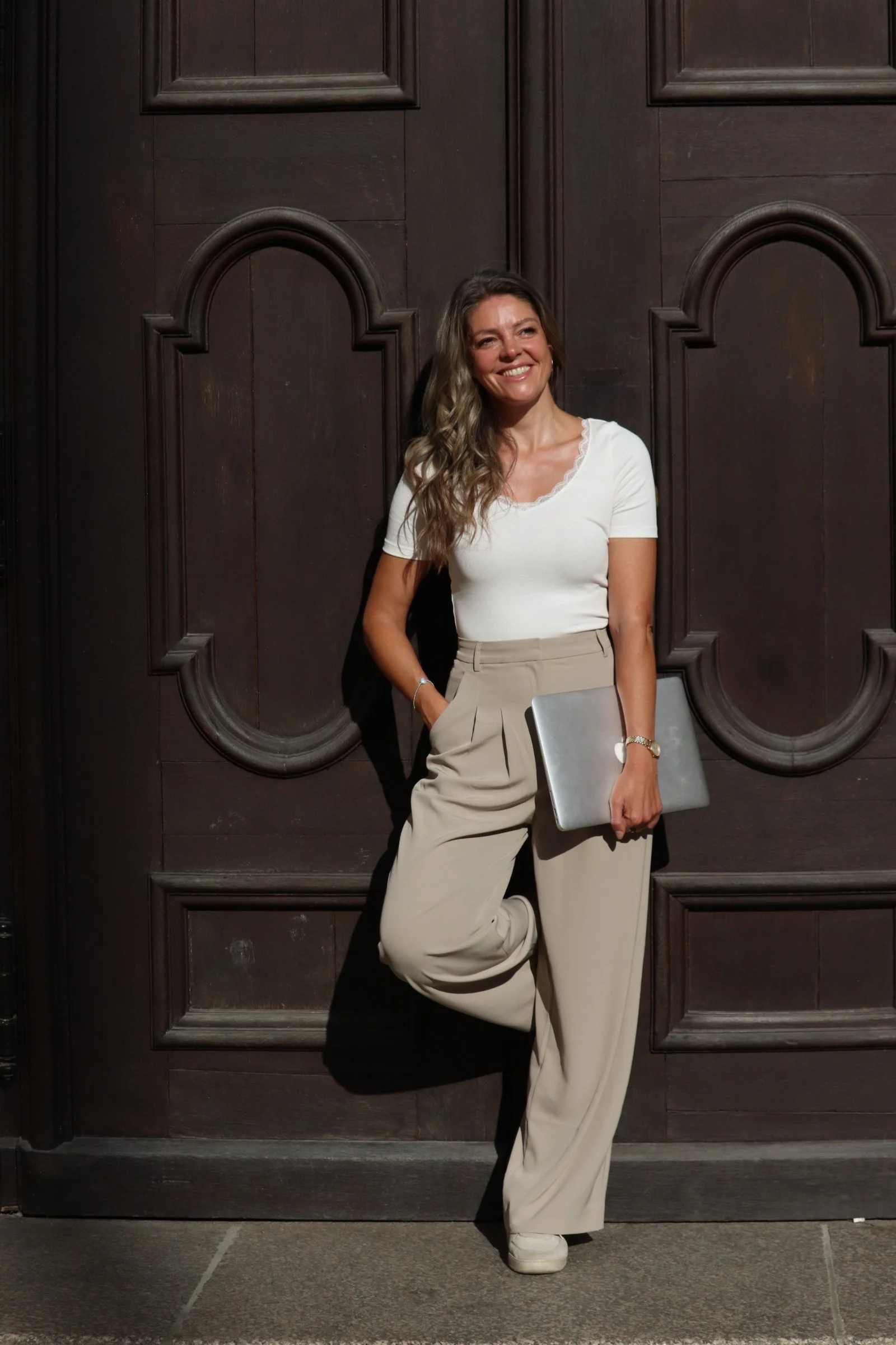Petra Psenner with her laptop in front of dark wood paneling—a health coach at work