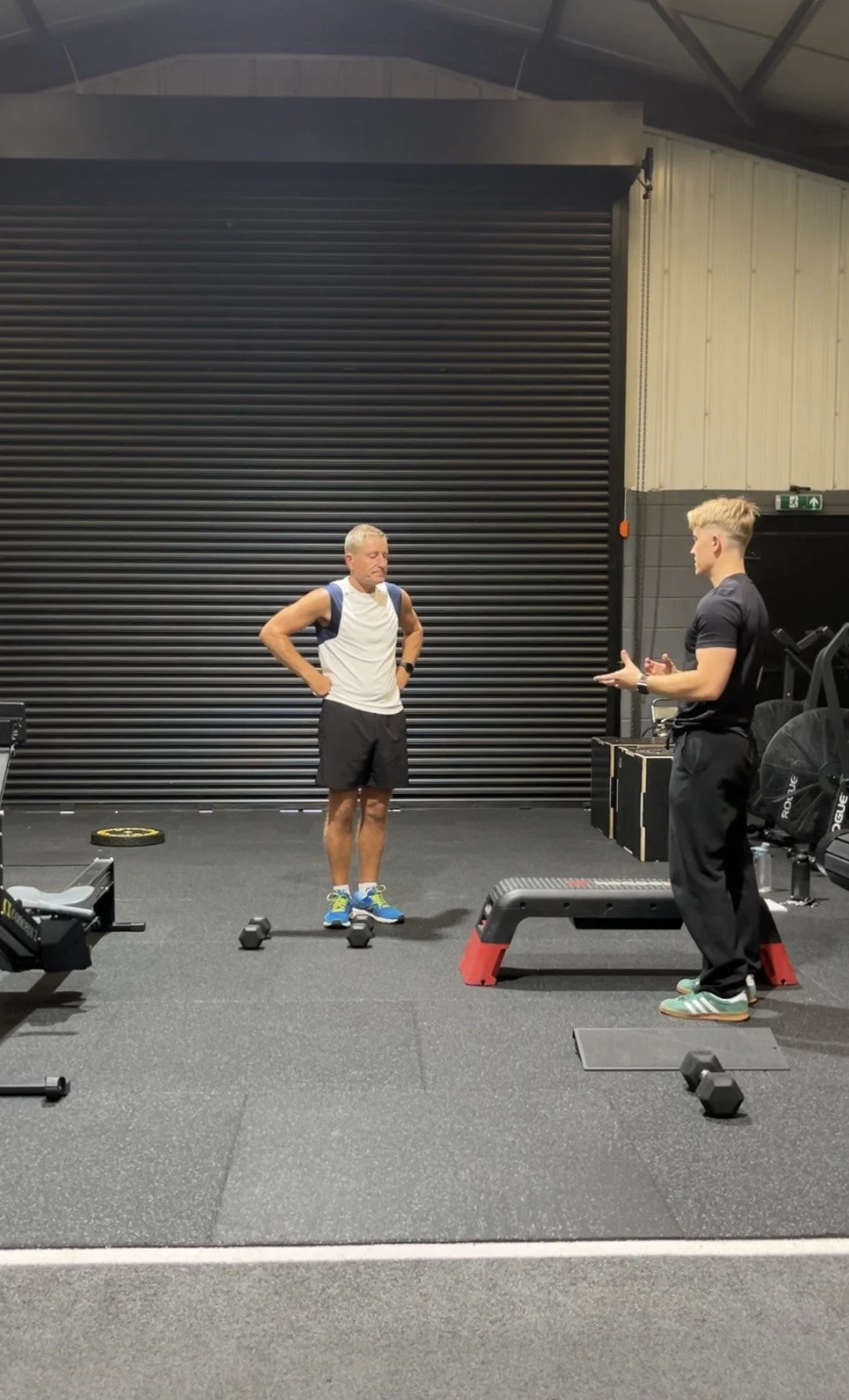 Two men in a gym having a conversation. This is a casual enquiry and conversation as part of a personal training consultation in Ashby De-La_Zouch.