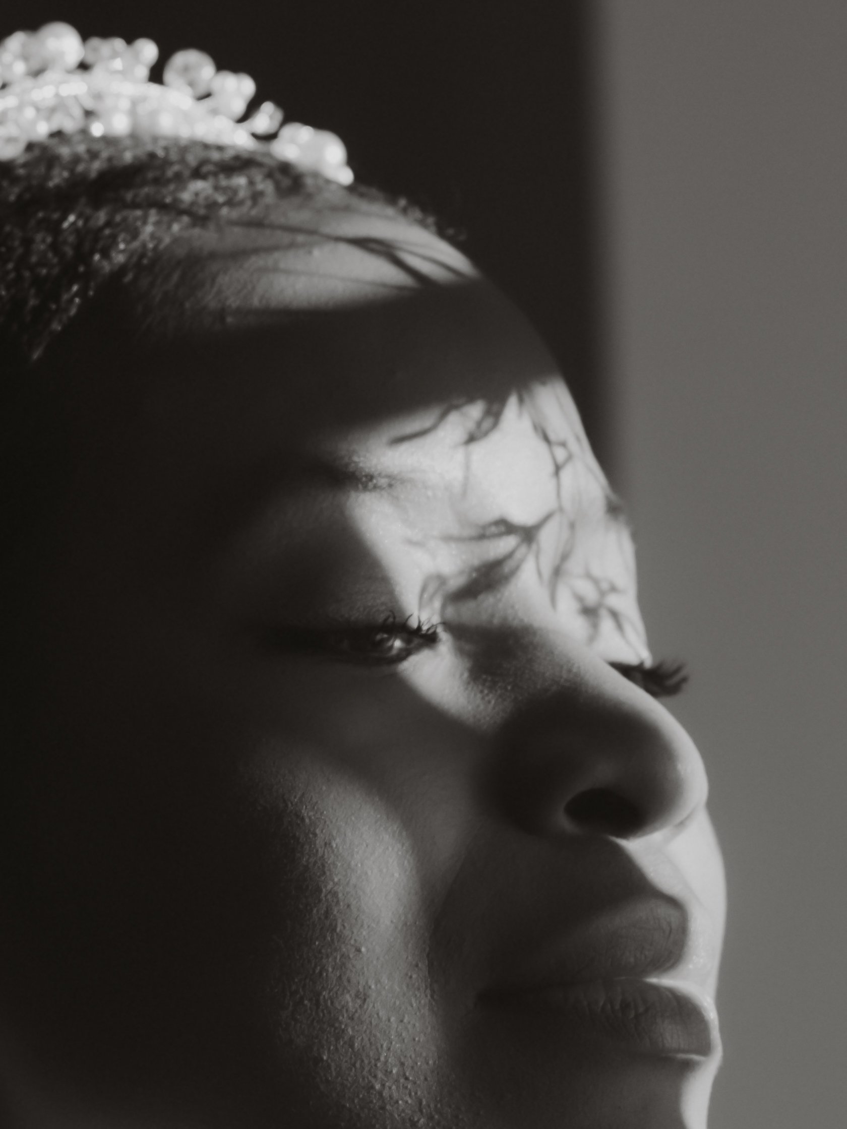 Close-up of a person's face in profile, with focus on the nose and closed eye, in black and white.