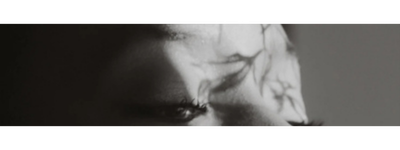 Close-up of a person's face, focusing on the eyes and forehead, in black and white.
