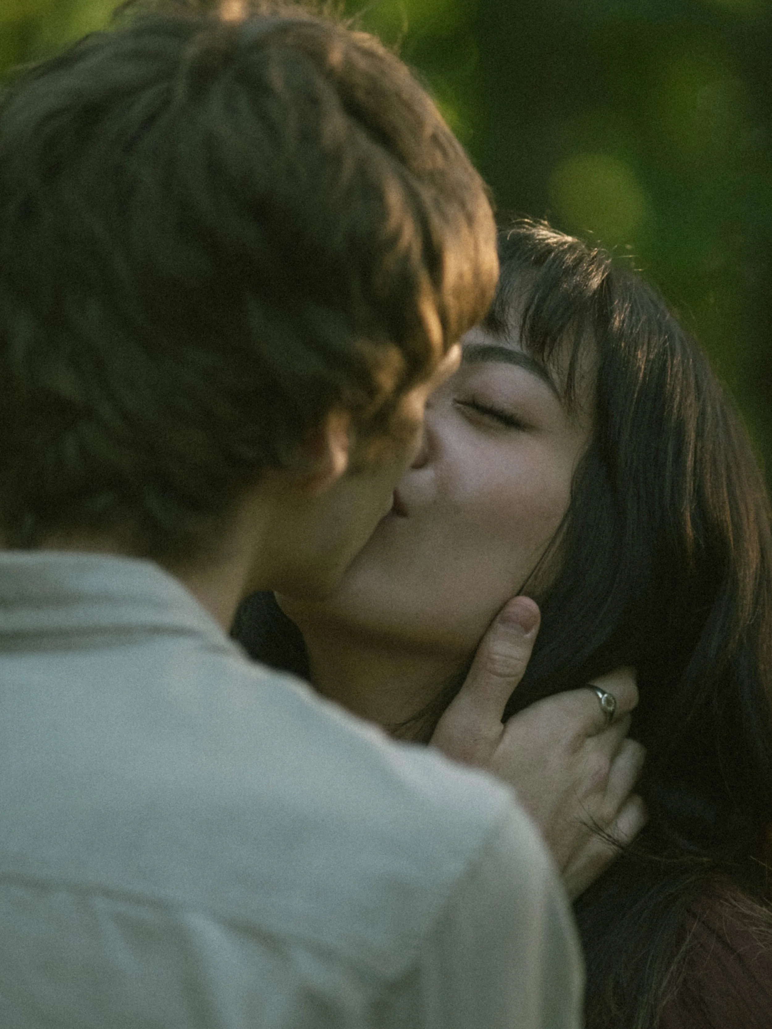 A close-up photo of a couple kissing, with one person's hand touching the other person's face.